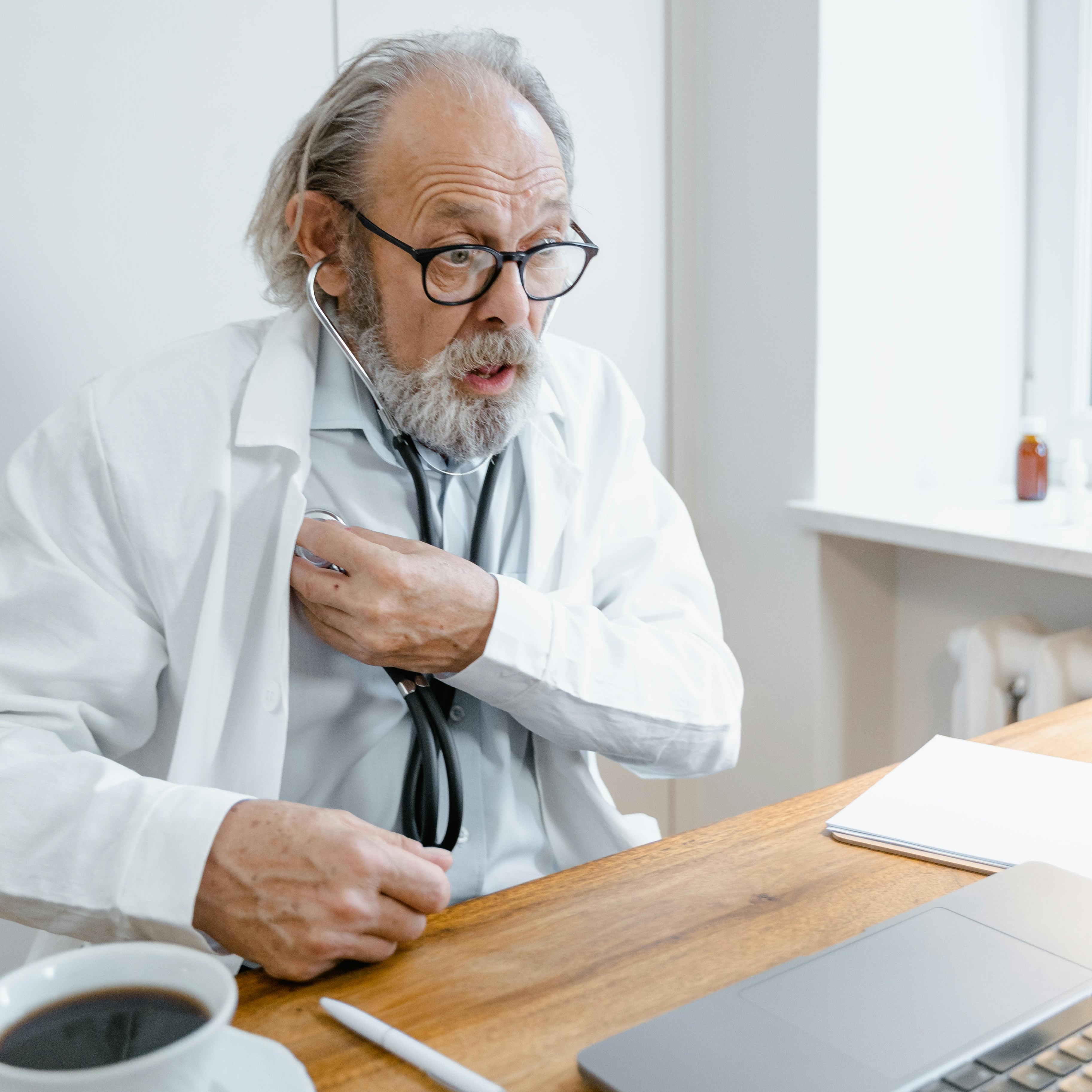 A doctor reacting to something while sitting at his desk | Source: Pexels