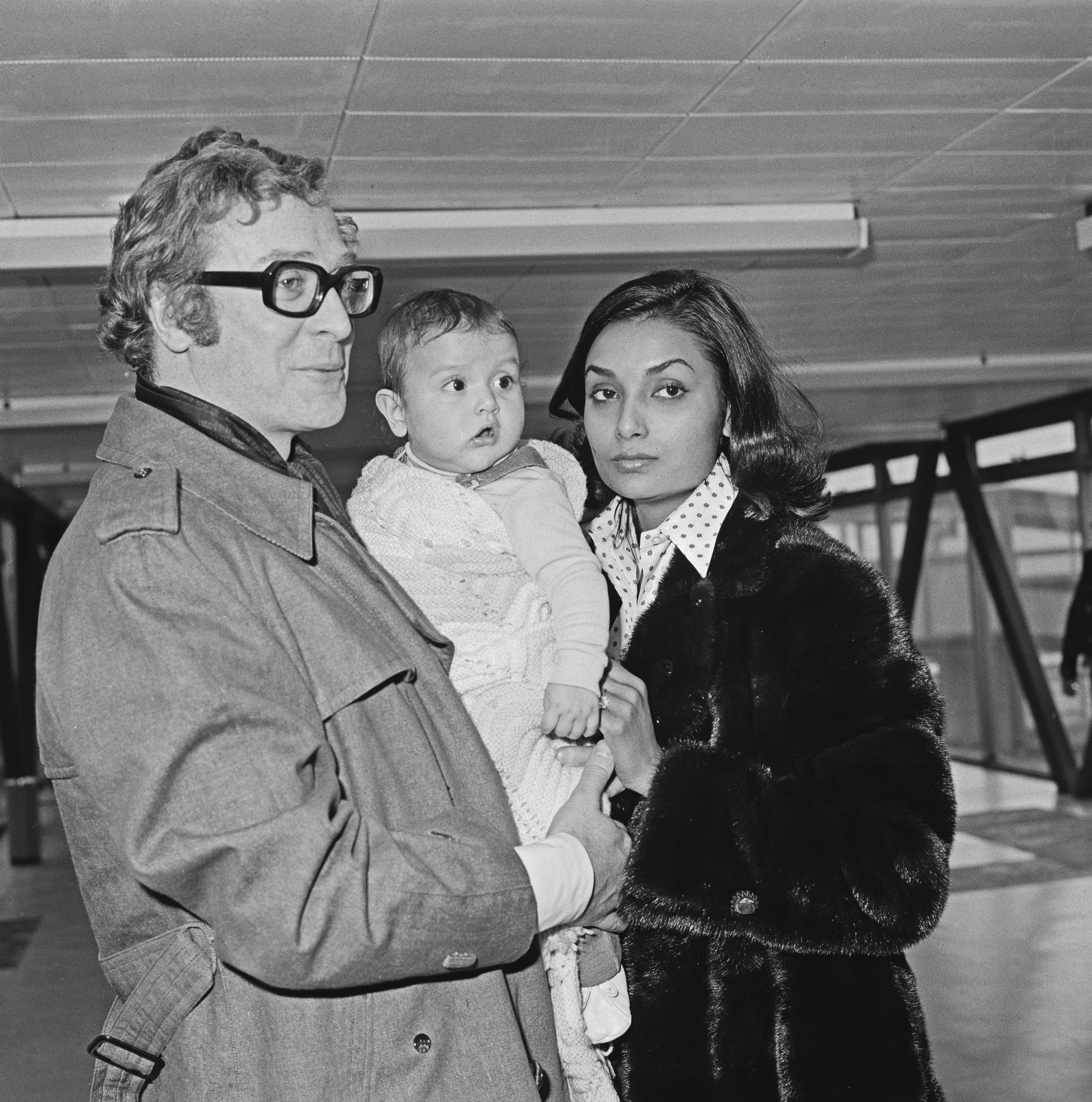 Michael Caine with Shakira Caine and their baby daughter Natasha at Heathrow Airport on 14 February 1974 in London, United Kingdom | Source: Getty Images