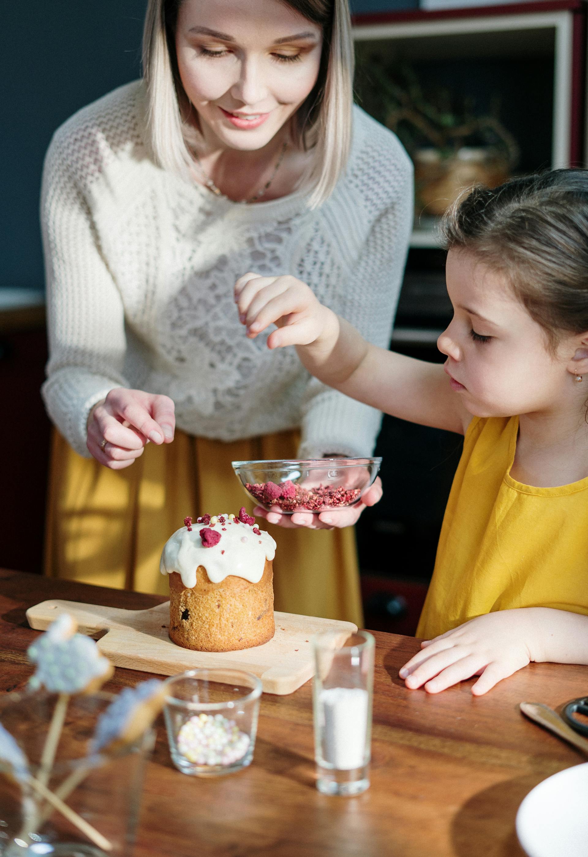 A woman and little girl decorating a cake | Source: Pexels