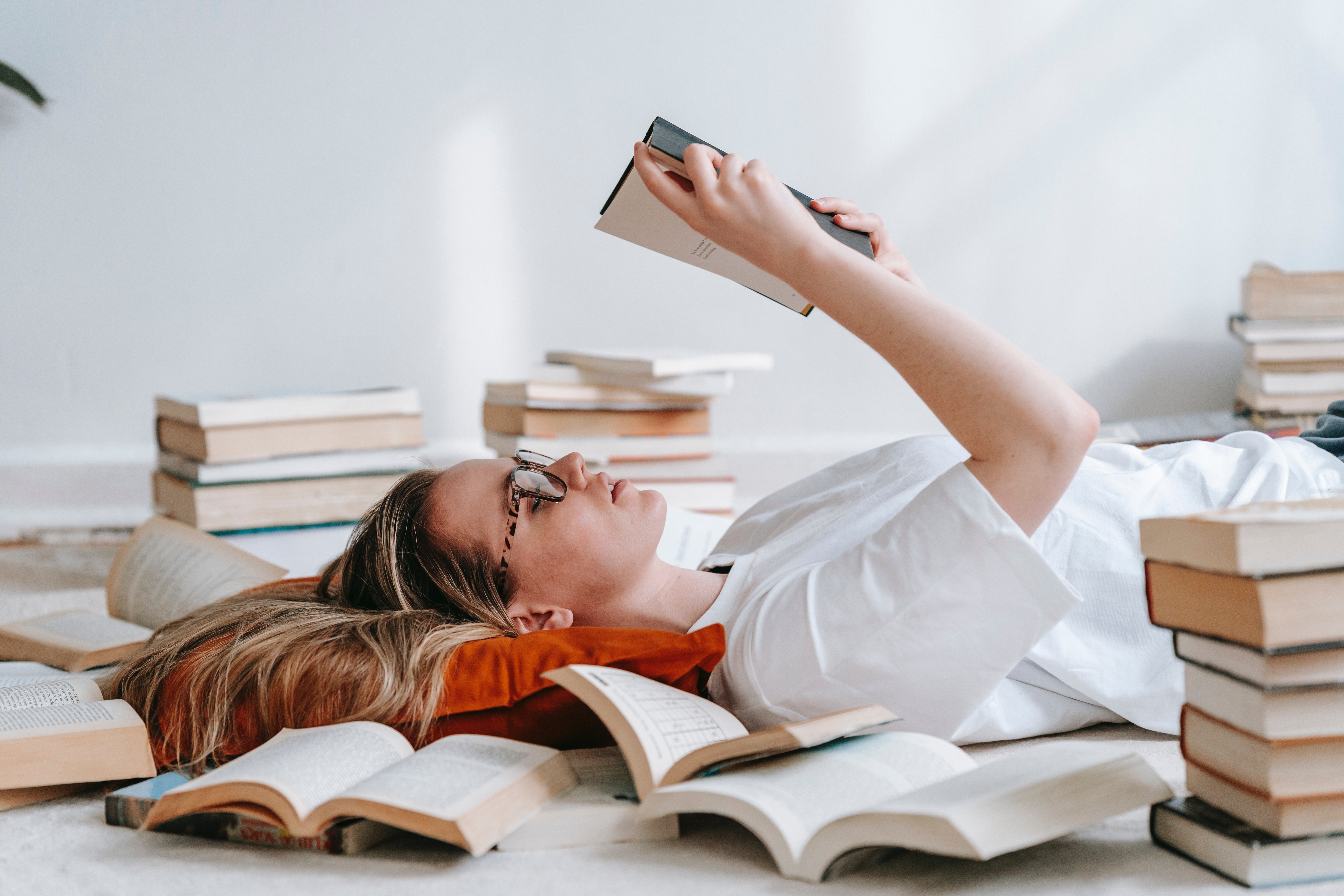 A woman surrounded by, and reading books | Source: Pexels