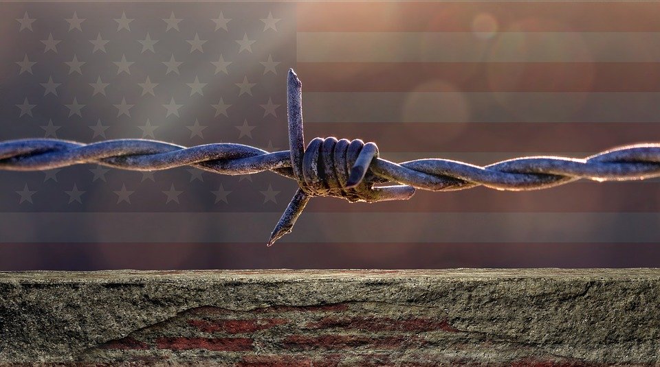 Bandera estadounidense tras alambre de púas. | Foto: Pixabay