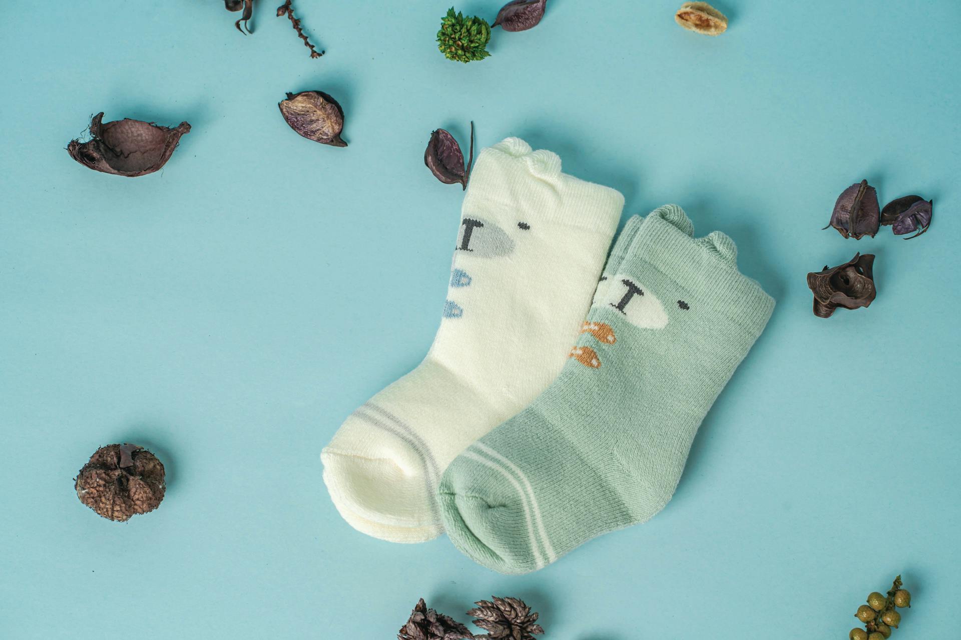 A close-up shot of baby socks lying on a blue surface | Source: Pexels