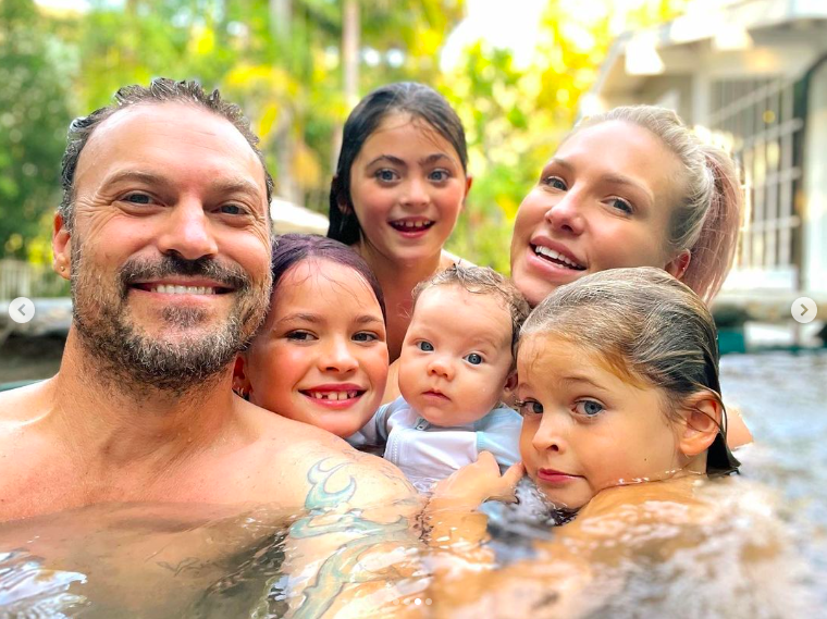 Brian Austin Green and Sharna Burgess with Noah, Bodhi, Journey and Zane Green, posing for a picture, posted on October 16, 2022 | Source: Instagram/brianaustingreen