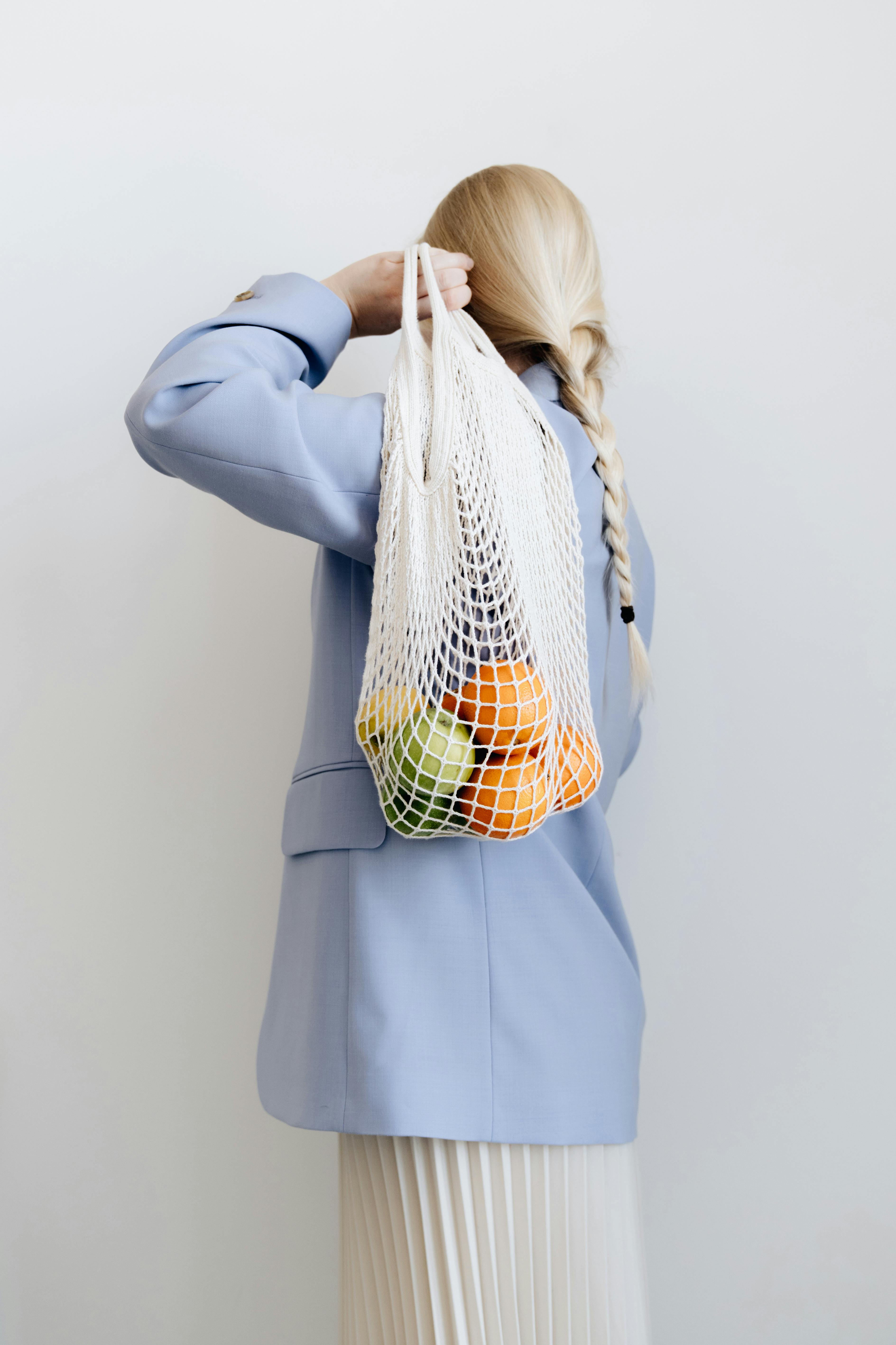 A woman holding a reusable grocery bag | Source: Pexels