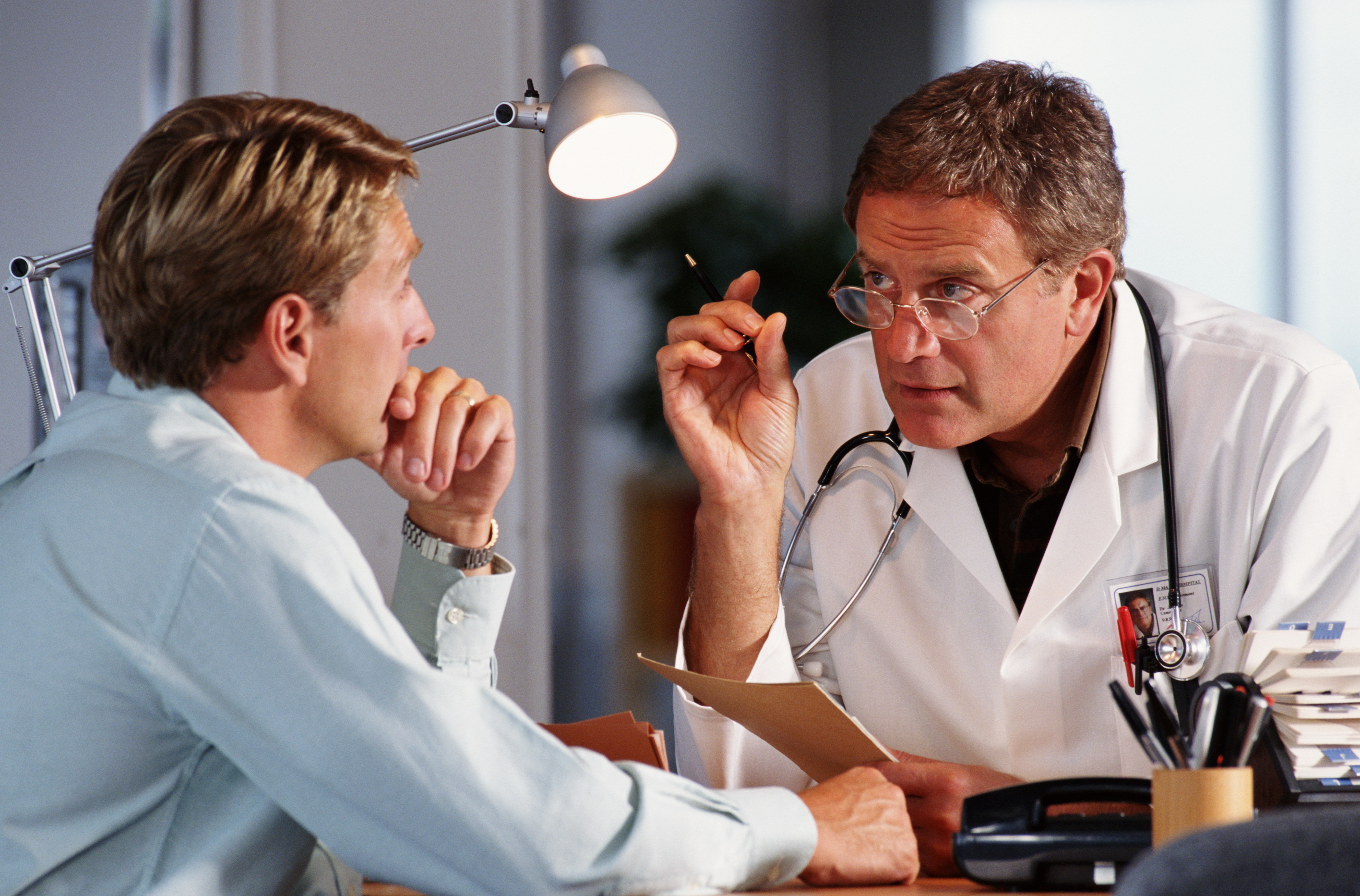 A doctor talking to a patient in his office | Source: Getty Images