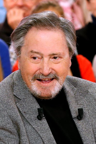 L'acteur Victor Lanoux, invité principal de l'émission, présente son livre "Deux heures a tuer au bord de la piscine" lors de l'émission "Vivement Dimanche".|Photo : Getty Images. L'acteur Victor Lanoux, invité principal de l'émission, présente son livre "Deux heures a tuer au bord de la piscine" lors de l'émission "Vivement Dimanche".|Photo : Getty Images.