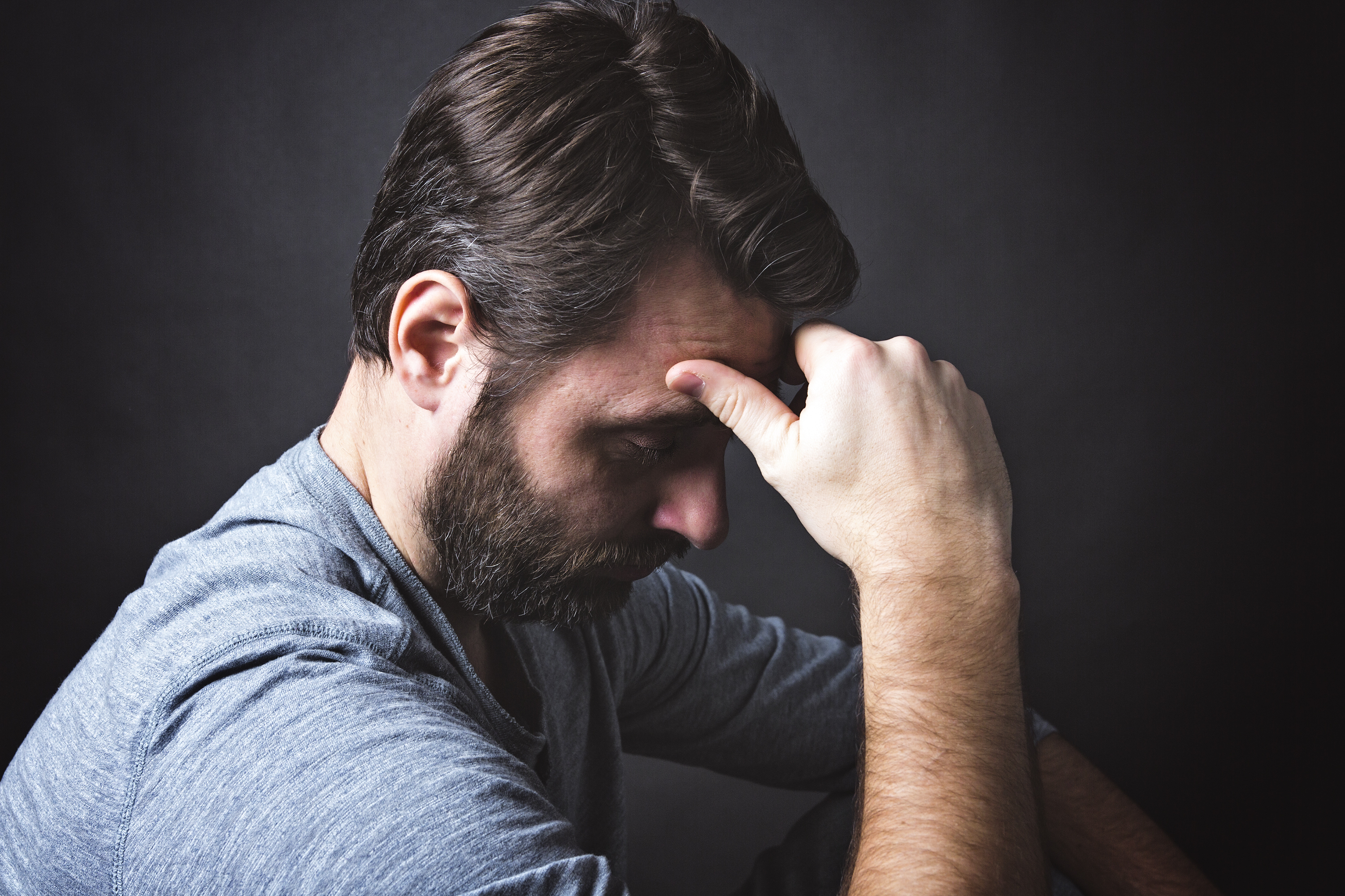 A depressed man with his hand on his forehead | Source: Shutterstock