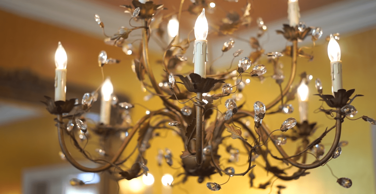 Donna Mills' chandelier in her gold-painted dining room. | Source: YouTube/@LosAngelesTimes