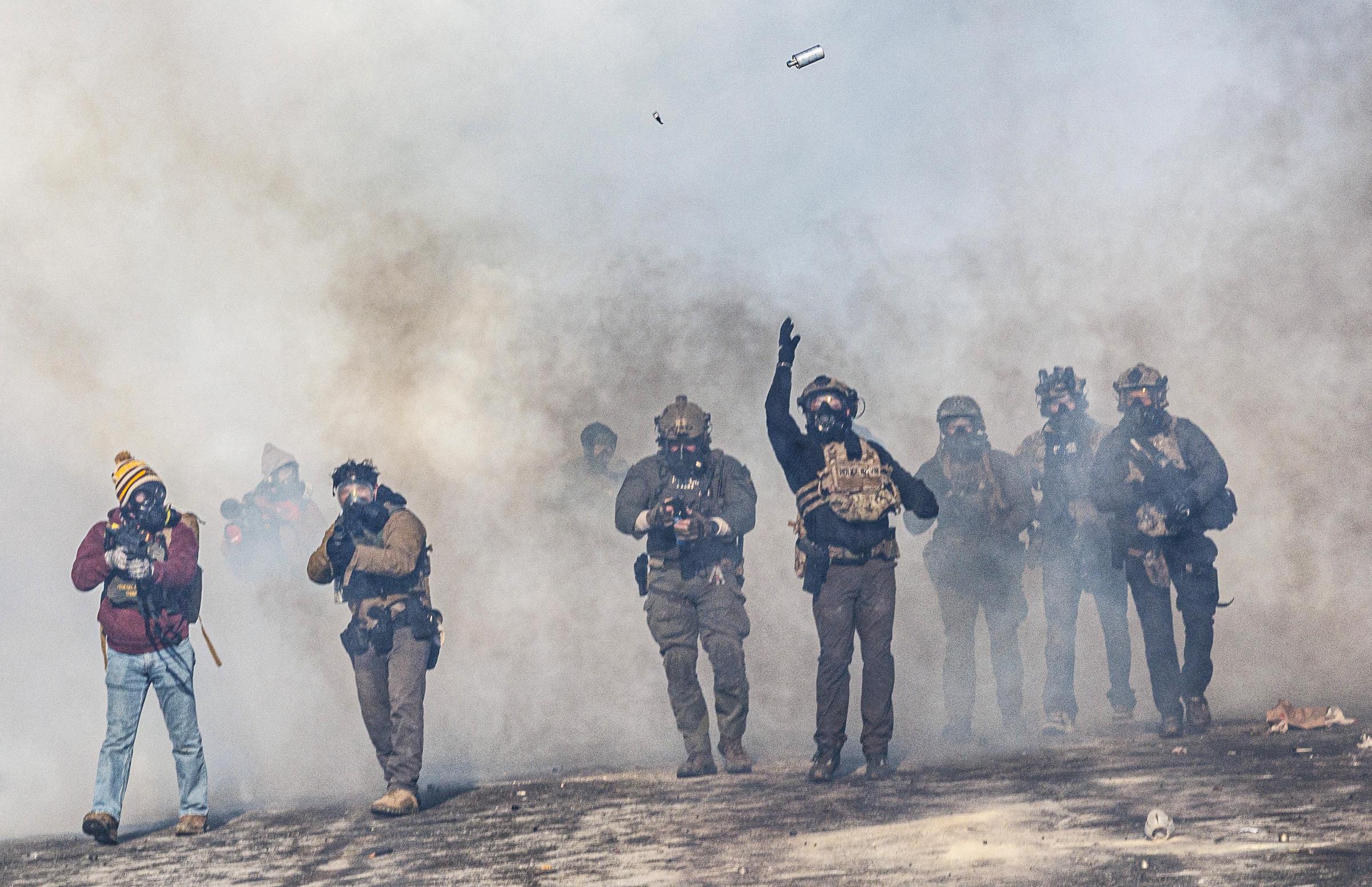A federal agent lobs a teargas canister towards protesters as agents advance through clouds of tear gas during clashes following the fatal shooting of Alex Pretti, on January 24, 2026 in Minneapolis, Minnesota. | Source: Getty Images