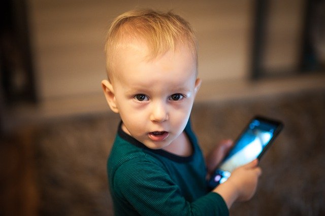 Niño con un teléfono en la mano. │ Foto: Pixabay