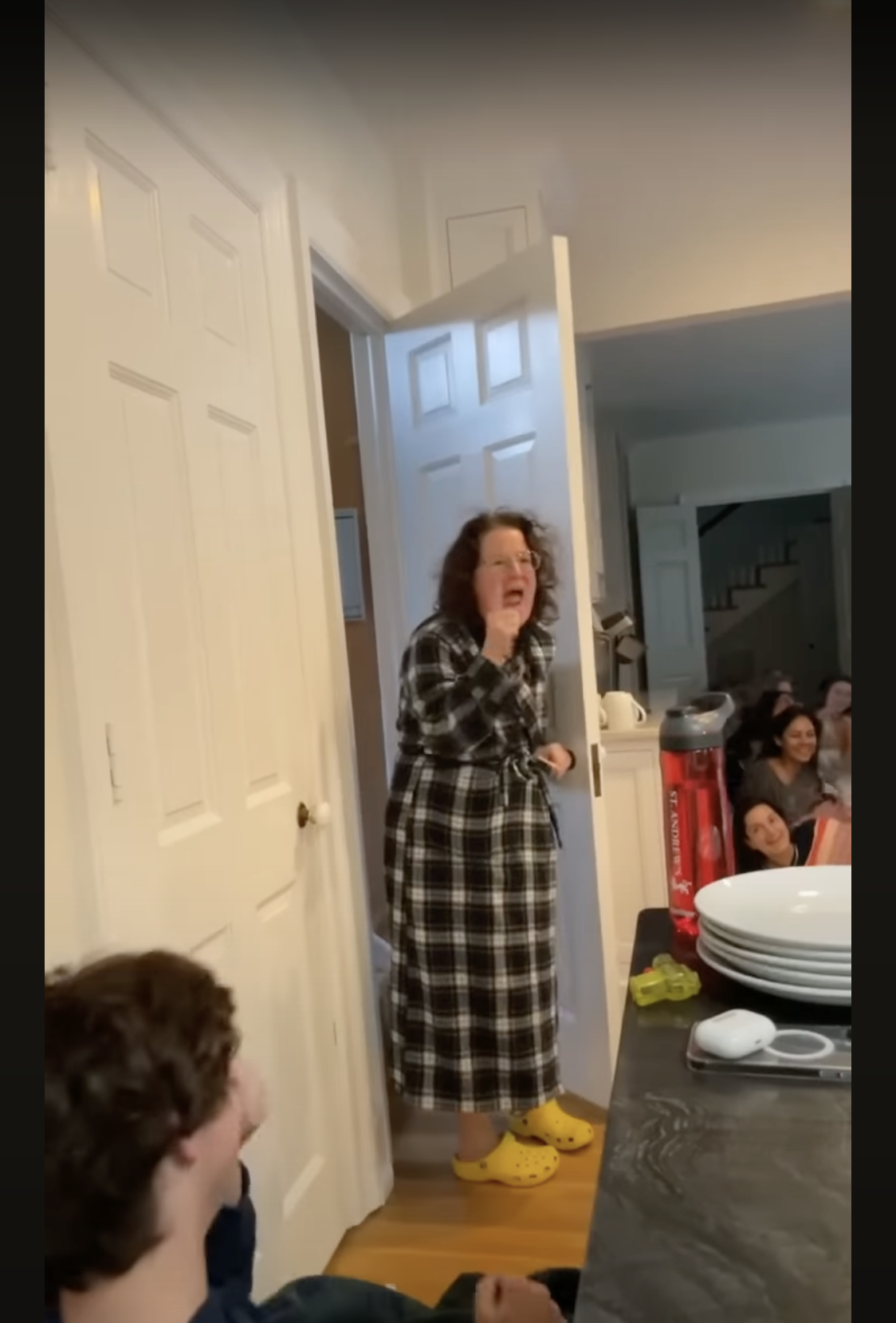 Joy McGrath is surprised to see the graduating class of 2023 sprawled on her kitchen floor, as seen in a video dated May 20, 2023 | Source: youtube.com/SASDelaware
