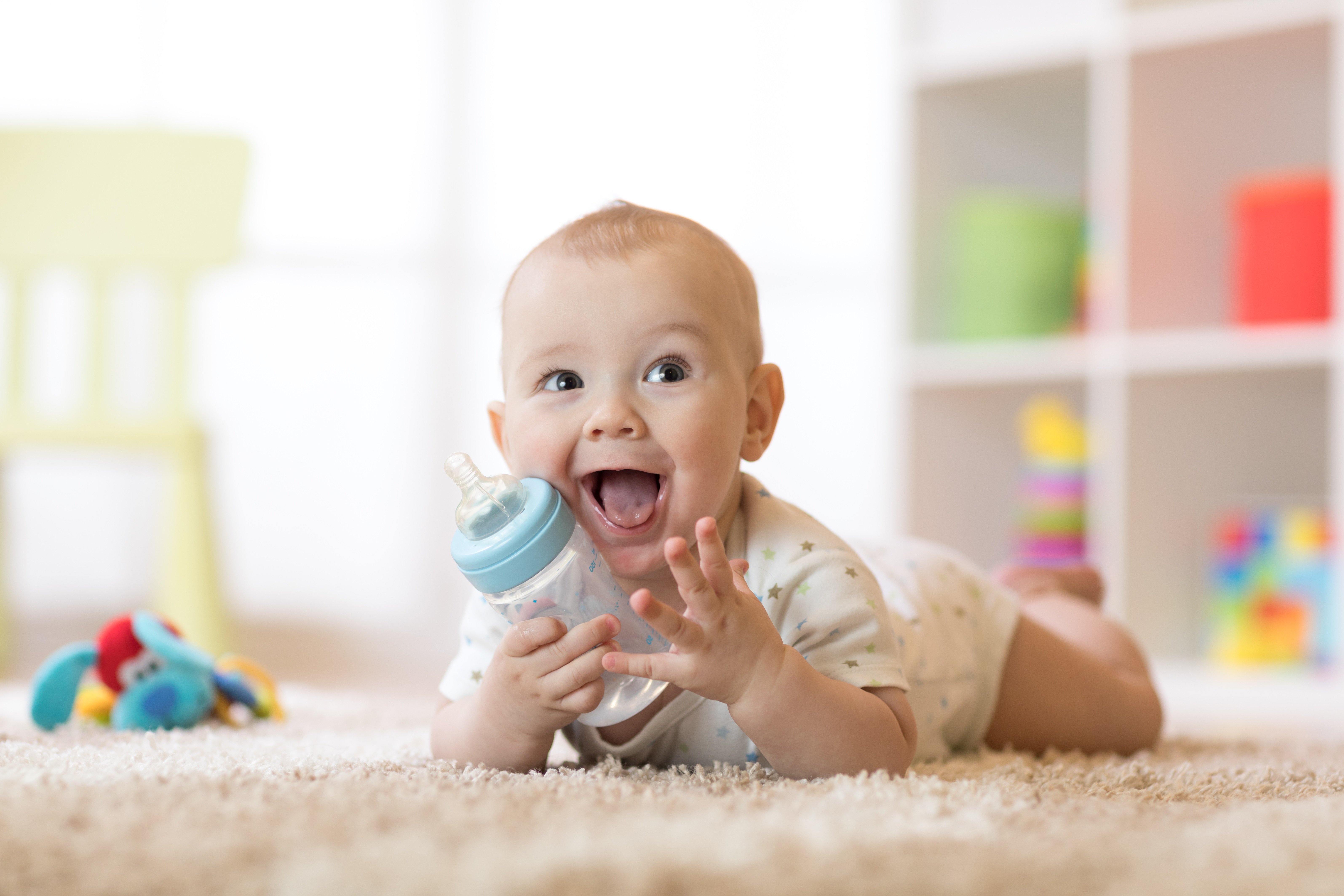 Kind, das zu Hause auf Teppich im Kinderzimmer liegt. | Quelle: Shutterstock