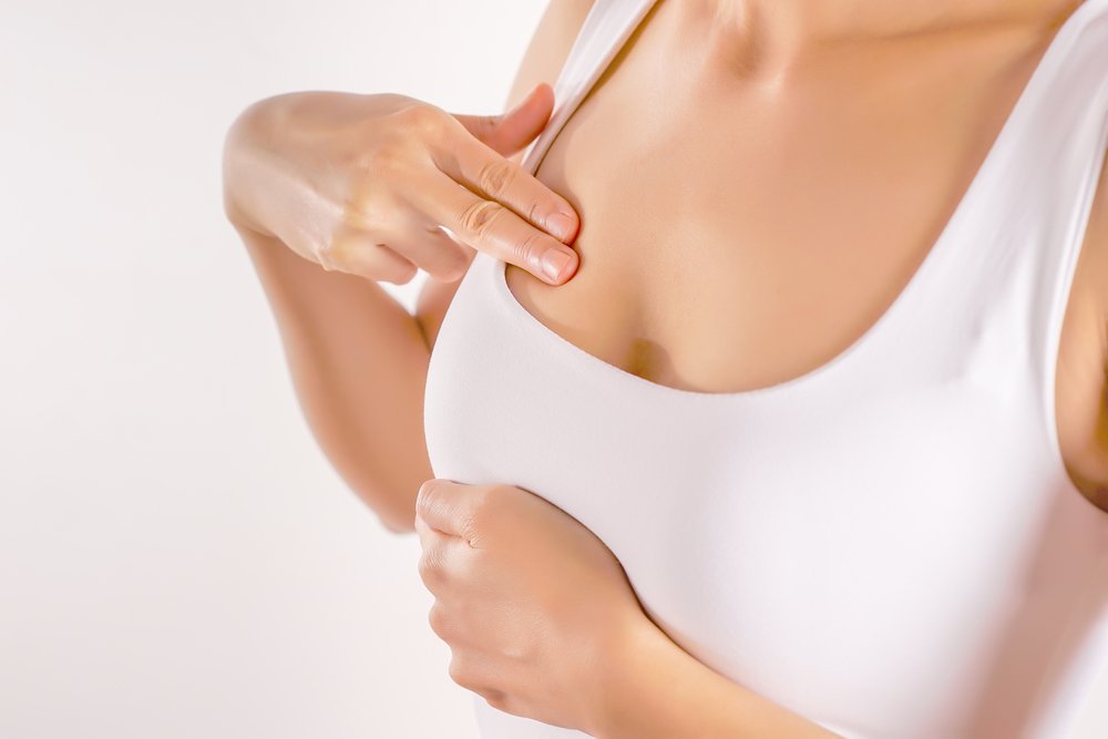 Woman Wearing A White Tank Top Checking Her Breast, Breast Self-Exam (BSE) | Photo: Shutterstock Woman Wearing A White Tank Top Checking Her Breast, Breast Self-Exam (BSE) | Photo: Shutterstock