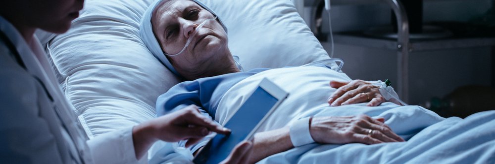 A terminally ill middle-aged woman looking sadly at her doctor. | Photo: Shutterstock