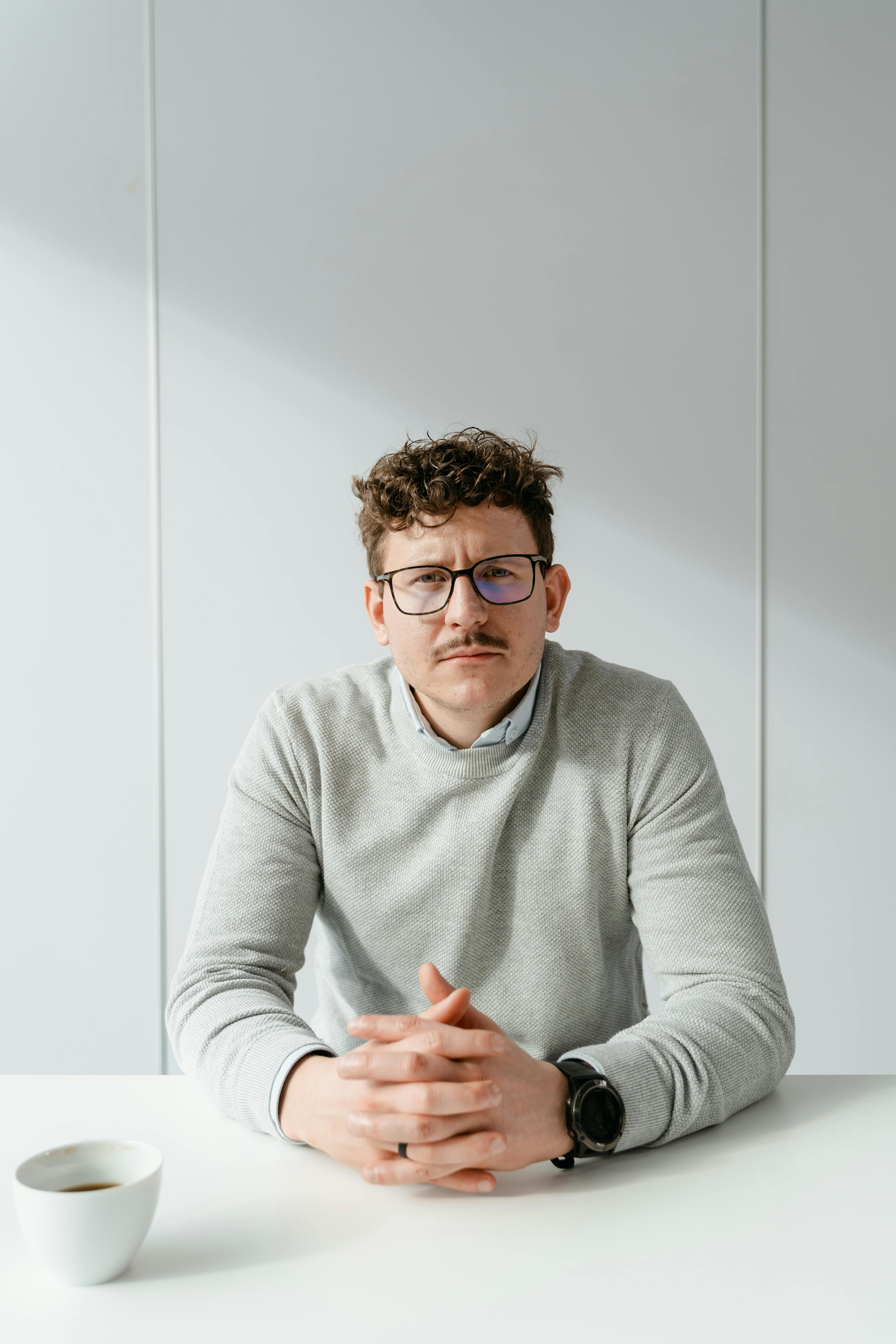 A serious man sitting at a table | Source: Pexels