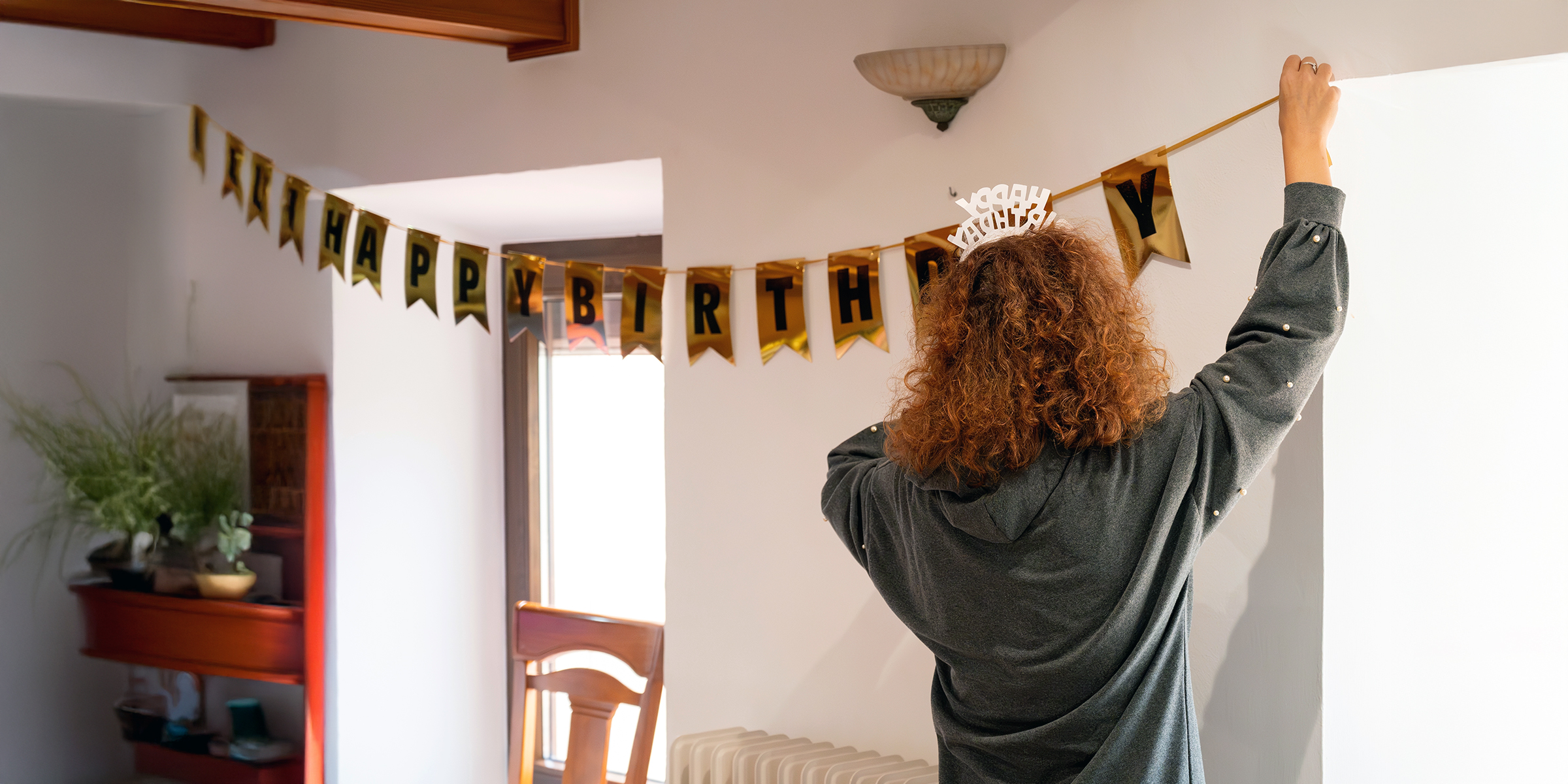 A woman hanging up birthday decorations | Source: Shutterstock