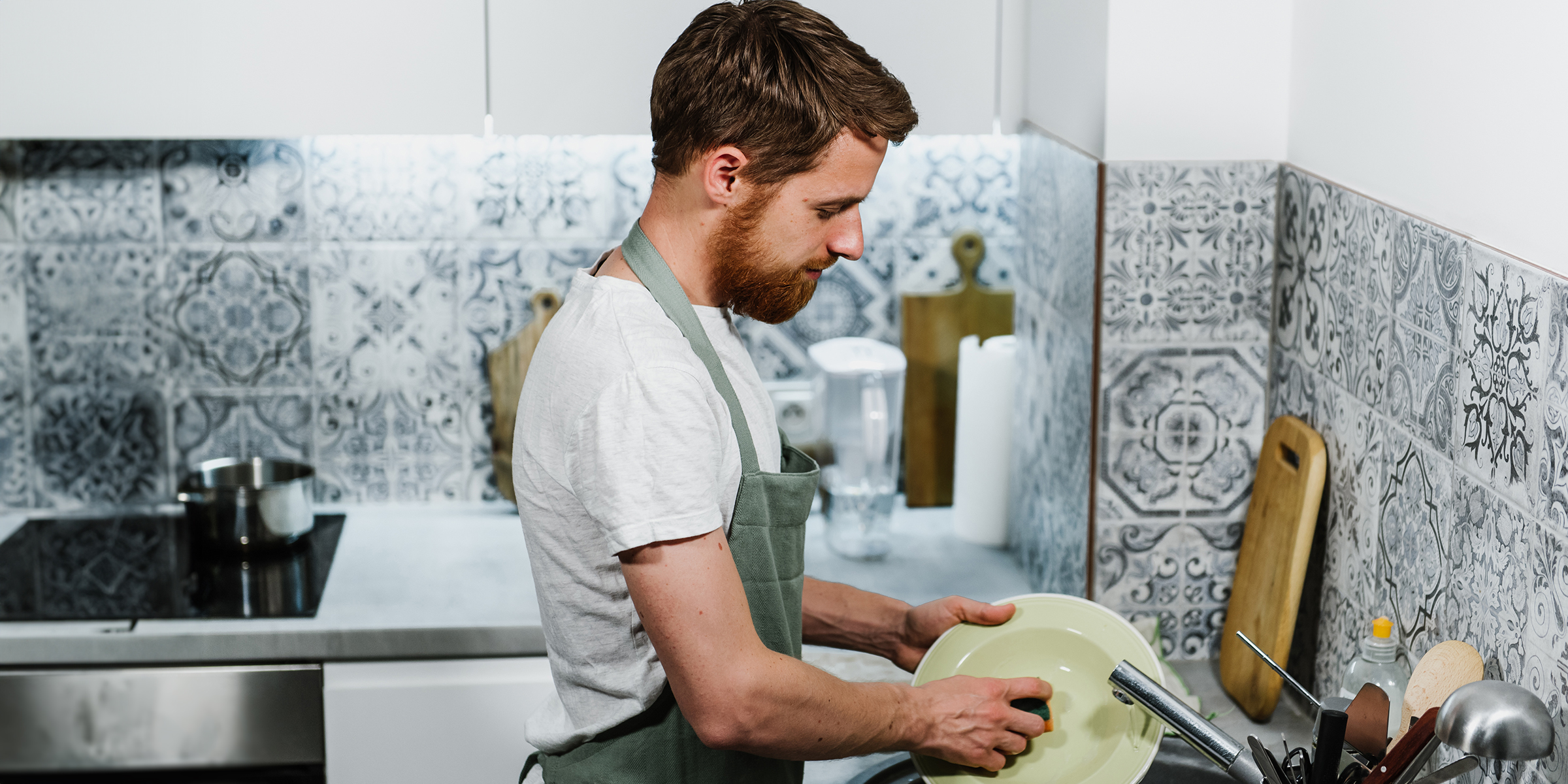 A man washing dishes in the kitchen | Source: Shutterstock