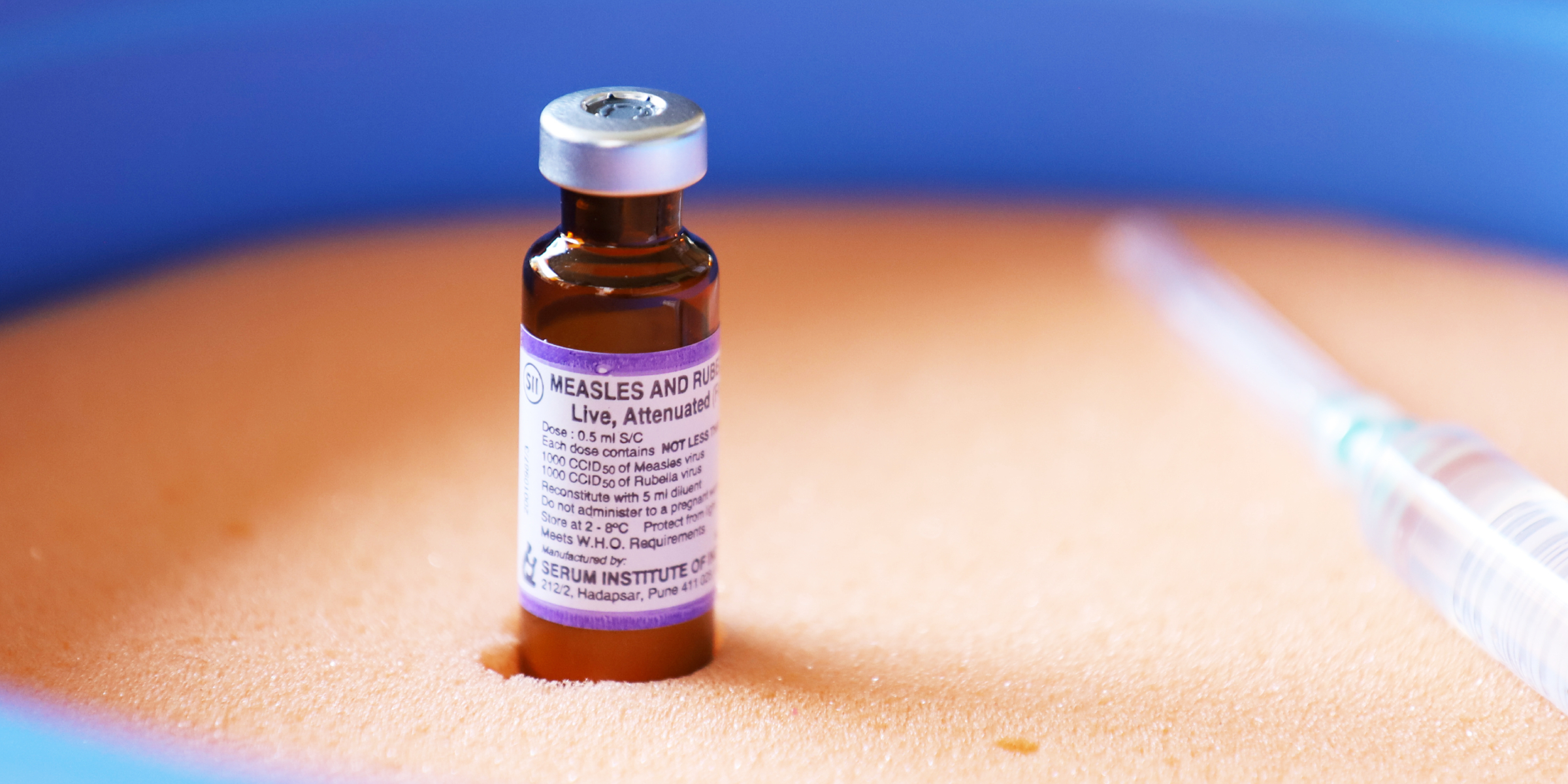 A vial of vaccine with a syringe in the background | Source: Getty Images