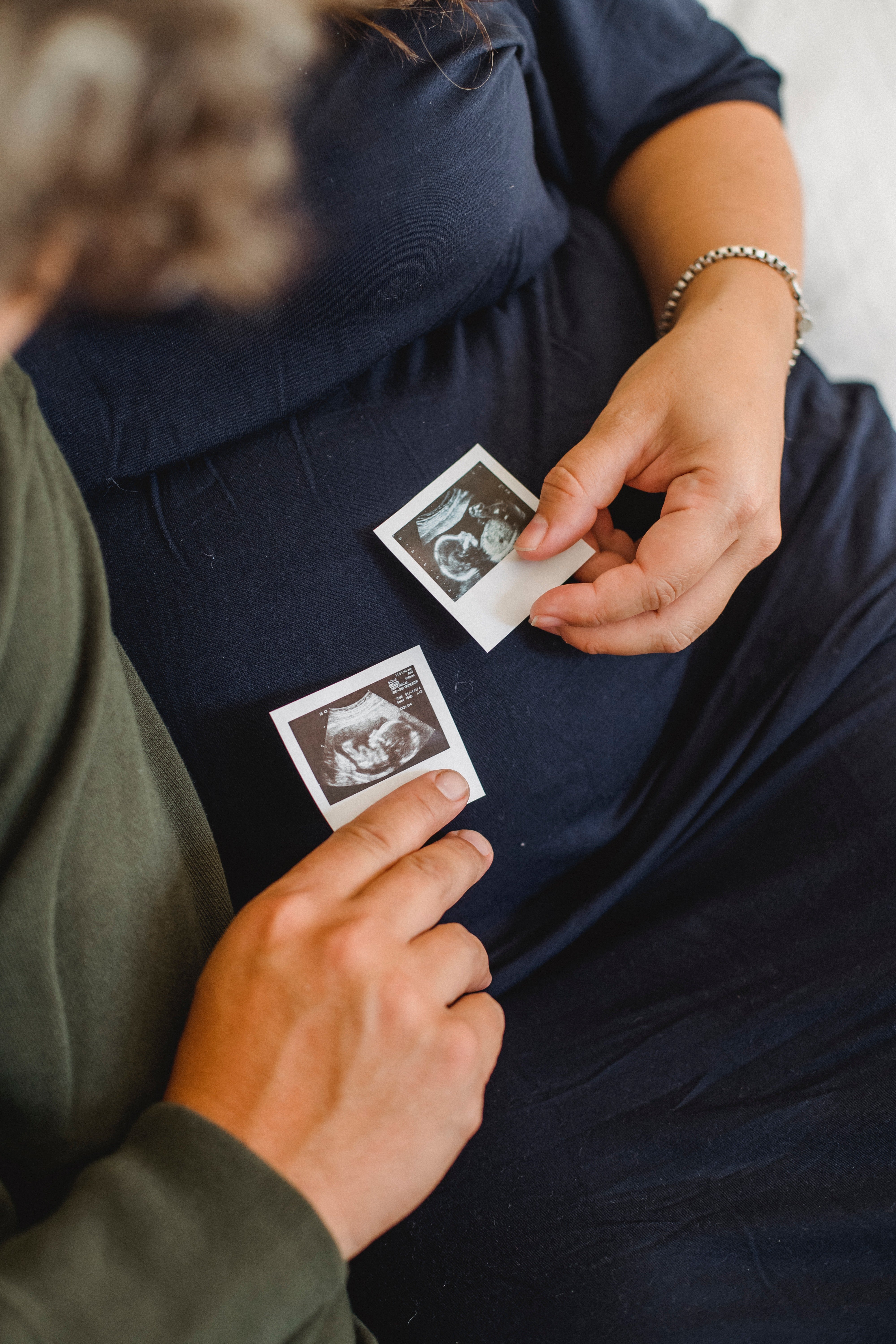 Pictured - An image of an expecting couple holding sonogram images close to the pregnant tummy | Source: Pexels 