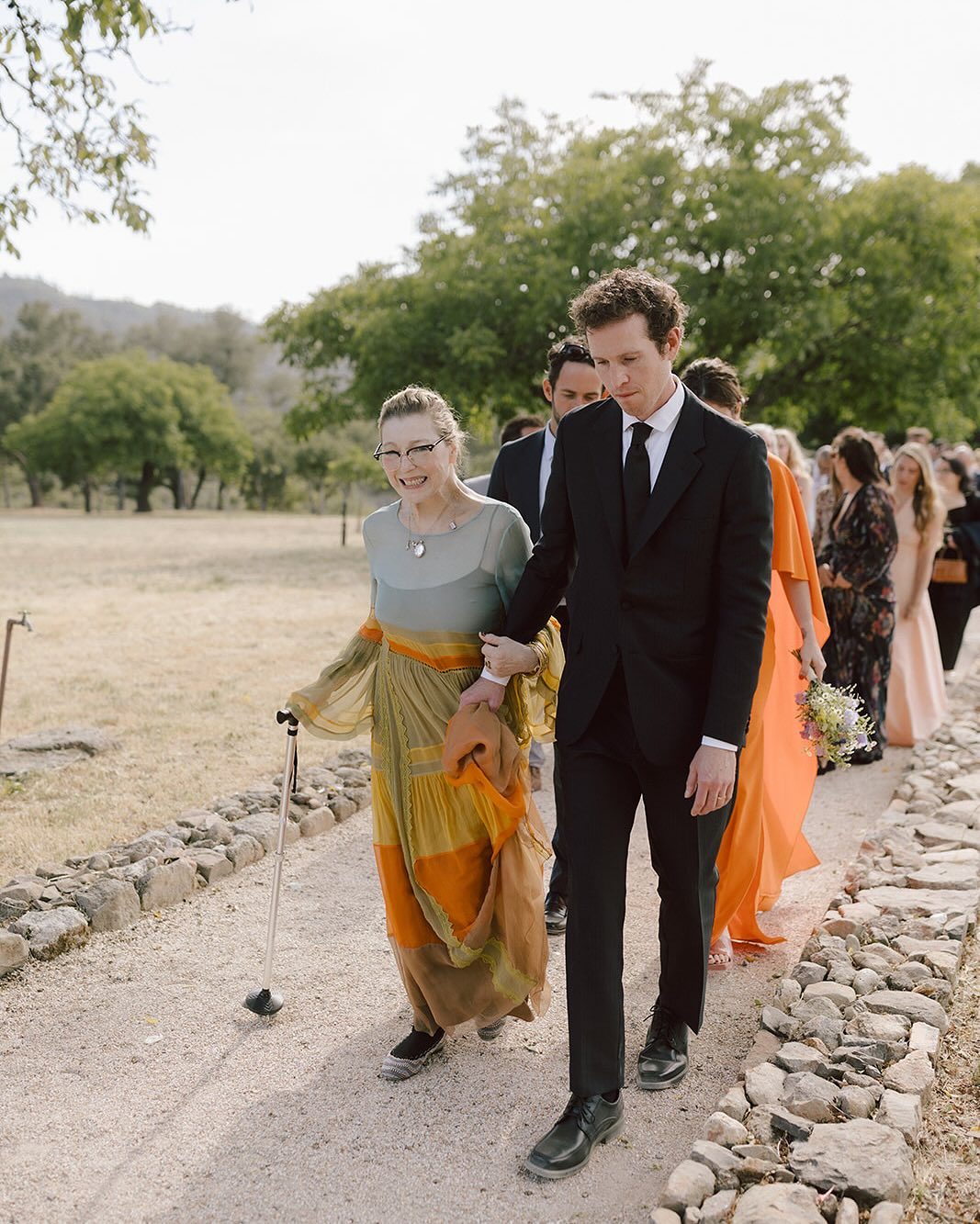 Tatum O'Neal walking with her son, Sean McEnroe, at Kevin McEnroe and Fern Cozine's wedding, from a post dated July 20, 2025 | Source: Instagram/tatum__oneal