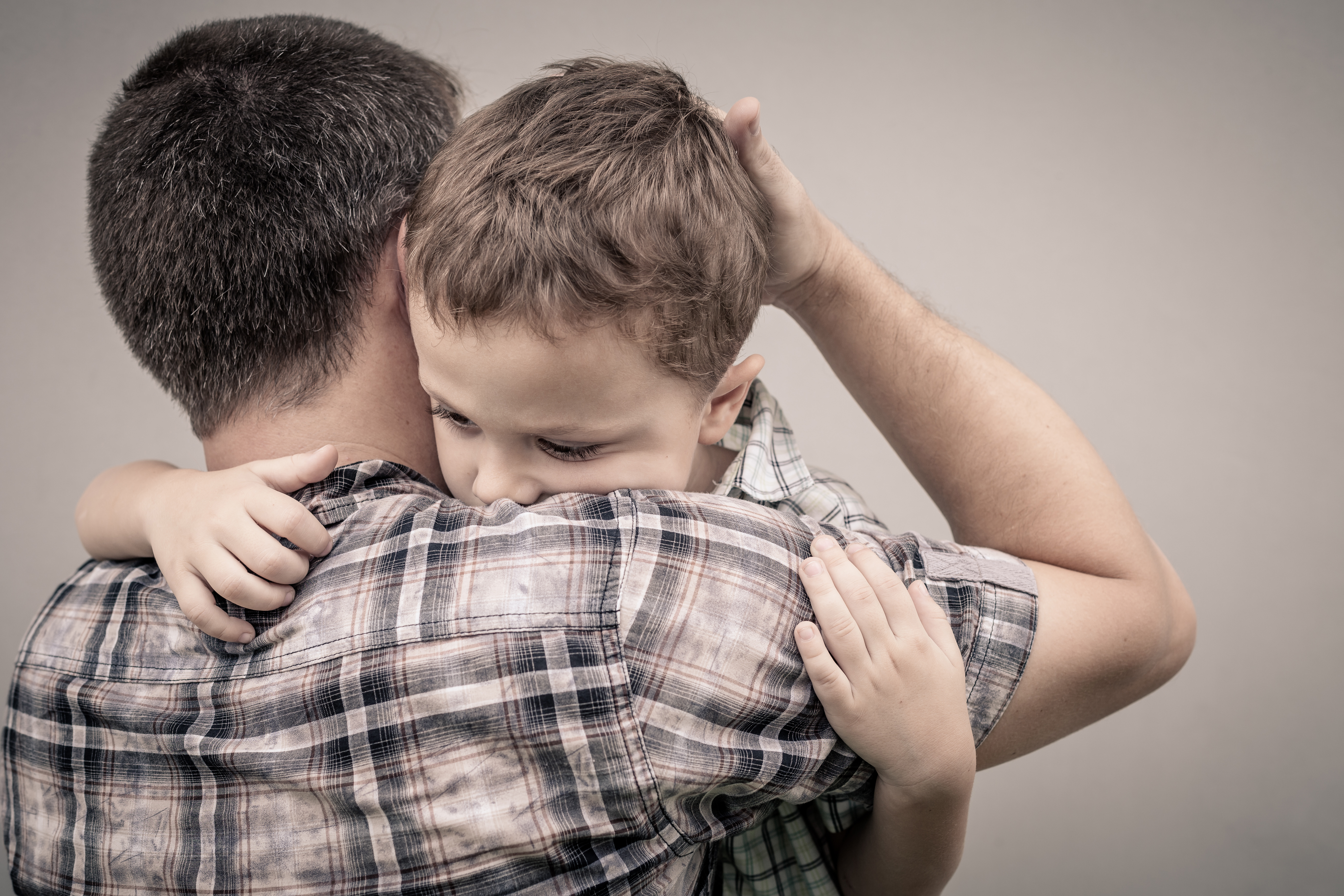 A father hugging his young son | Source: Shutterstock