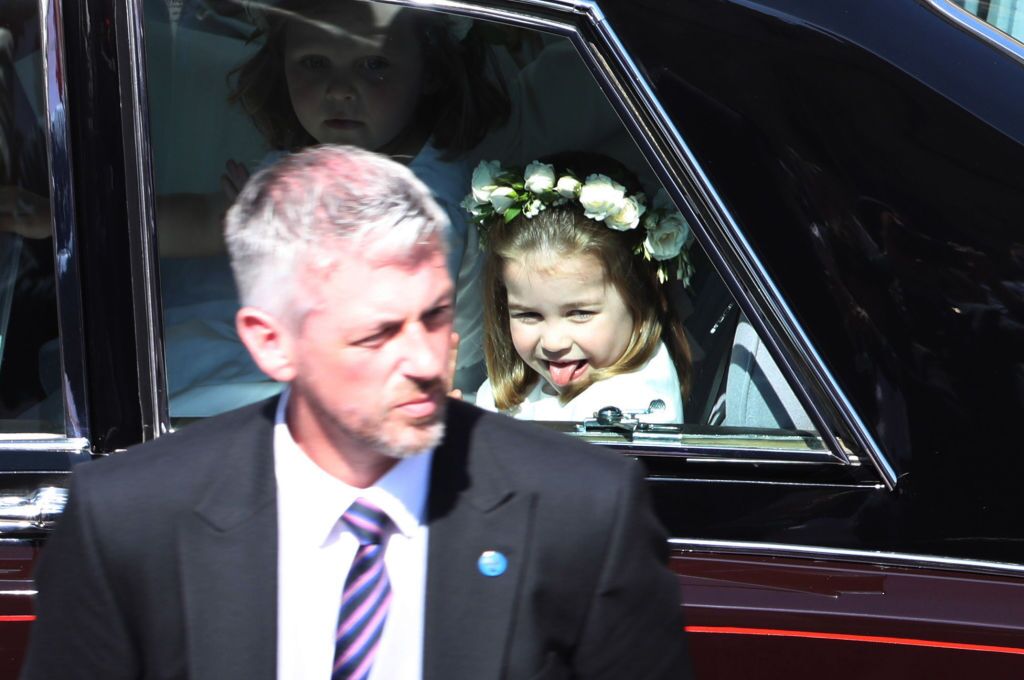 Princess Charlotte waves to the crowd as she rides in a car to the wedding of Prince Harry and Meghan Markle | Getty Images