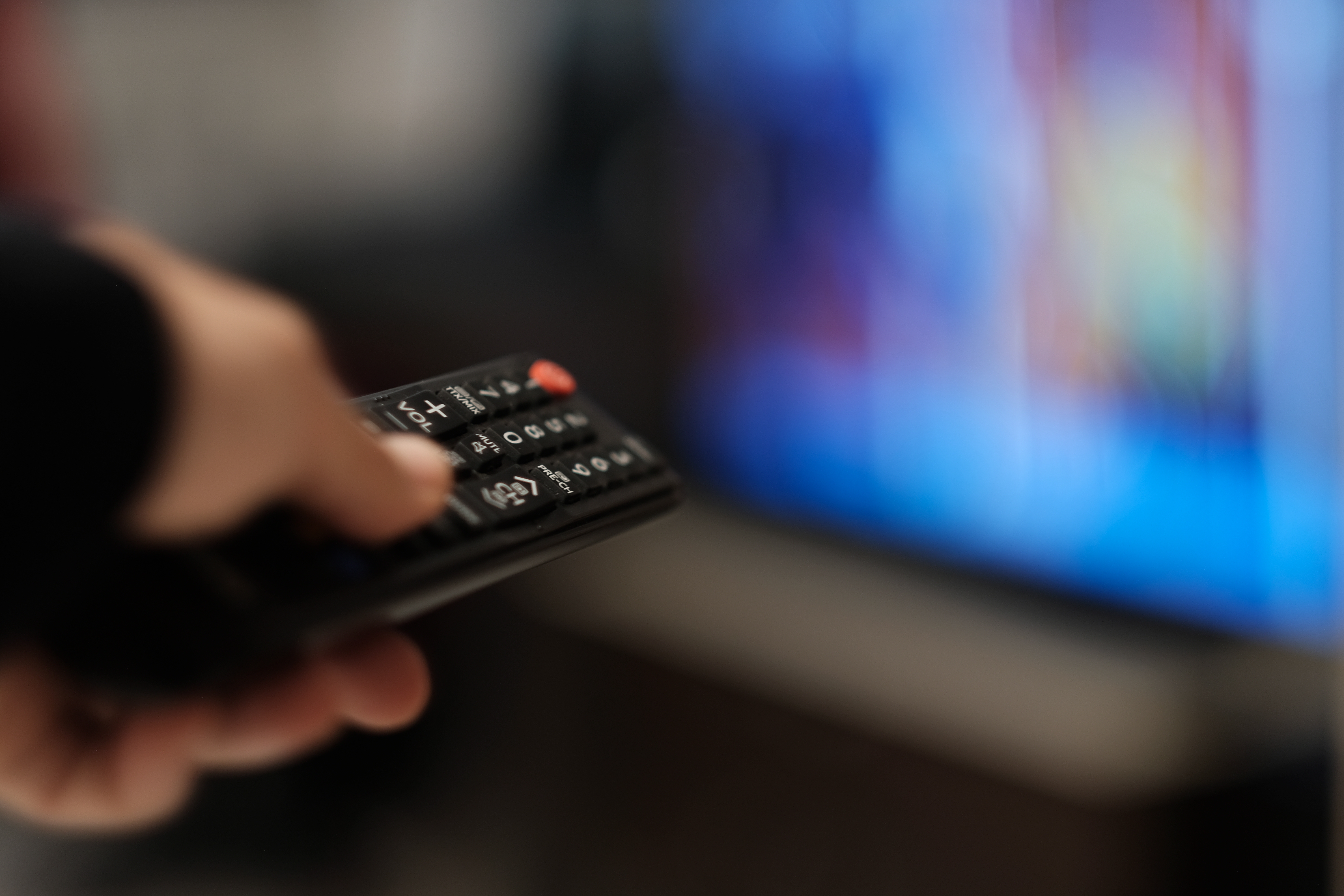 A person pointing a remote at a TV | Source: Getty Images