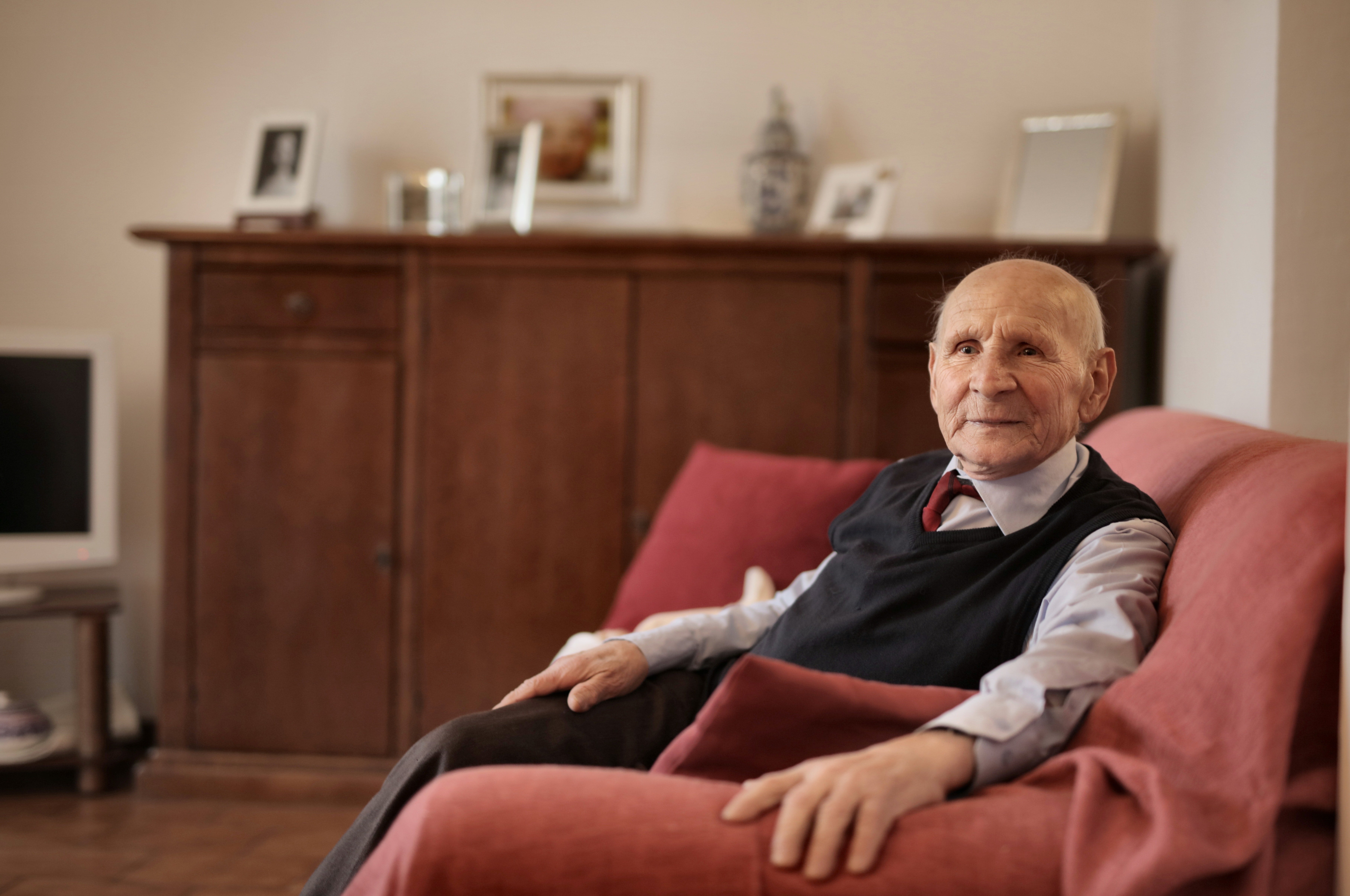 An elderly man sitting on a couch. | Pexels/ Andrea Piacquadio