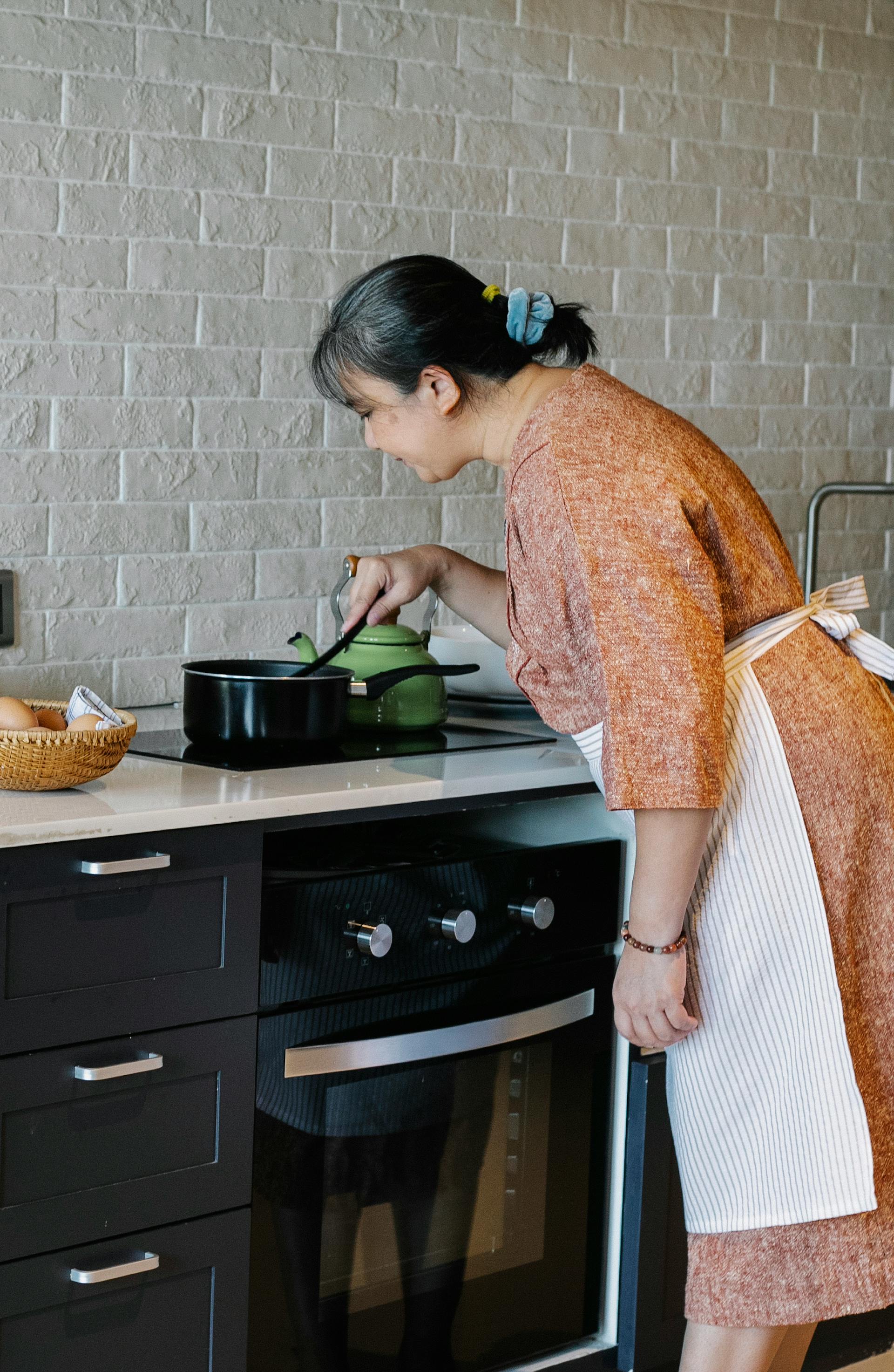 A senior woman stirring a pot in the kitchen | Source: Pexels
