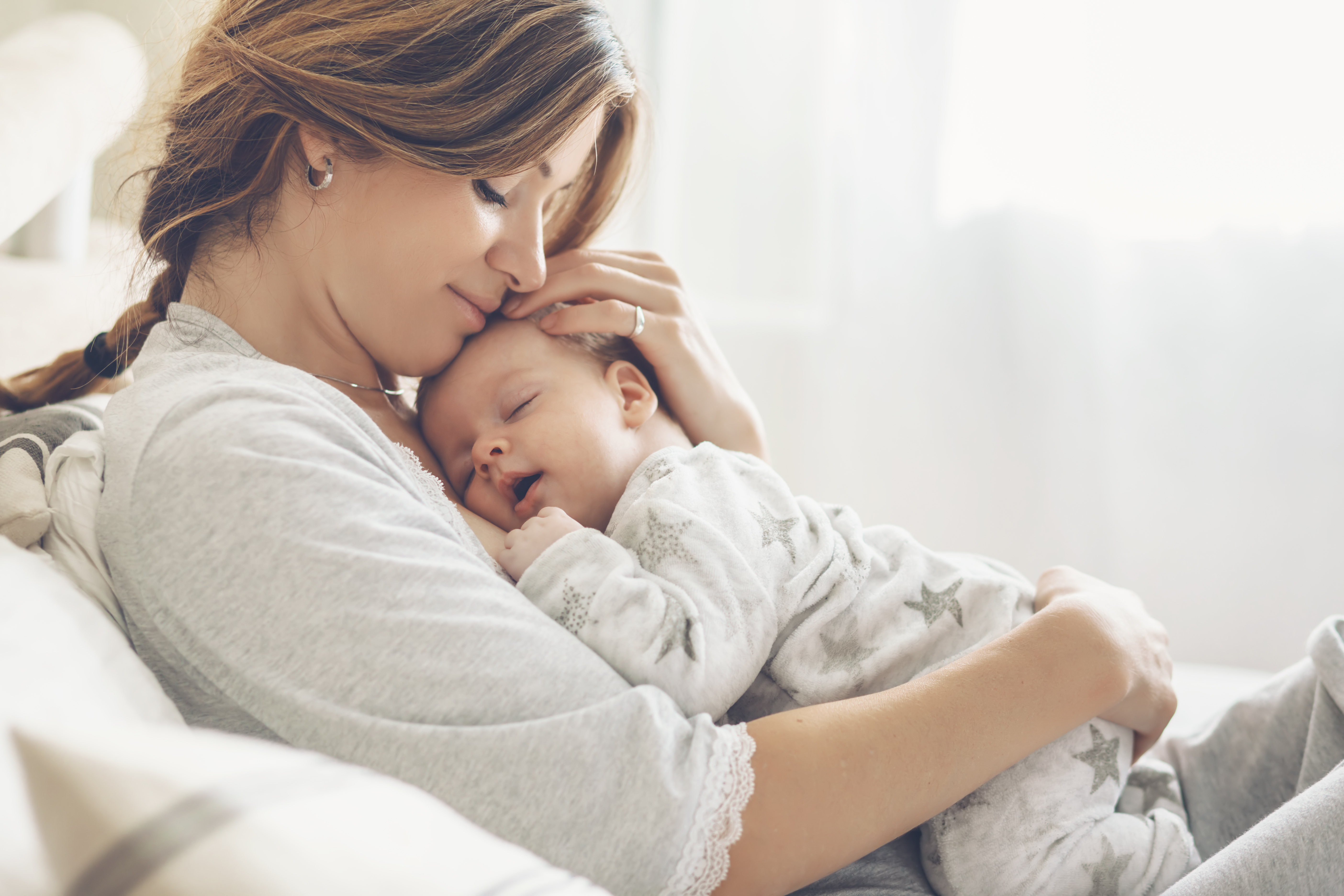 A mother cuddling her newborn child | Source: Shutterstock