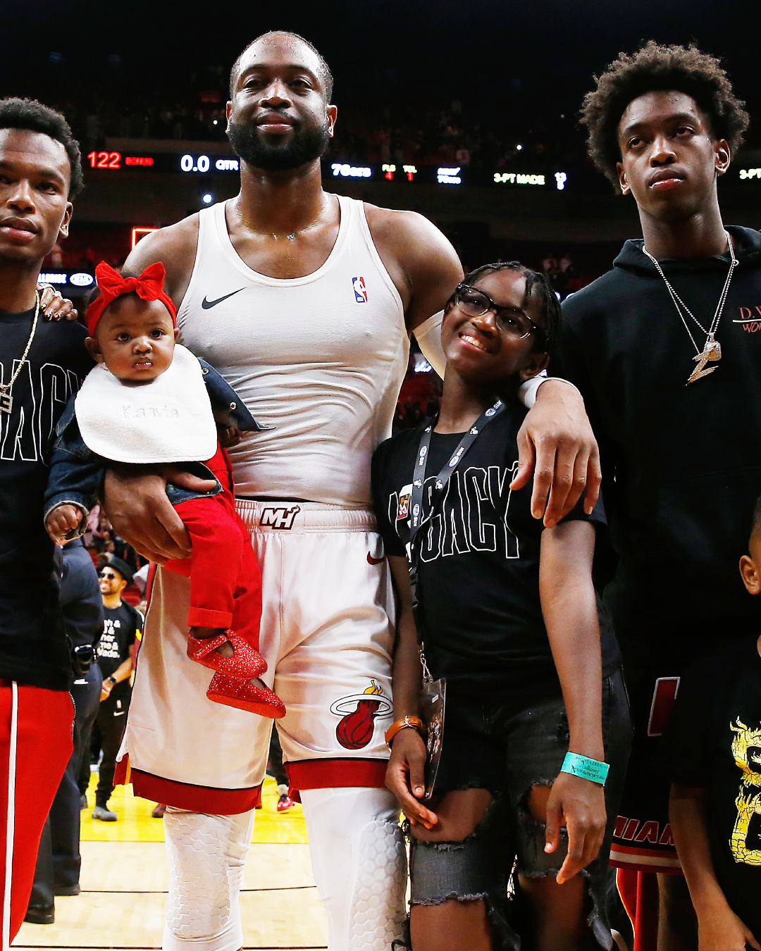 Dwyane Wade stands with Zaire Wade and Zaya Wade while holding Kaavia James Union Wade on the court following his final home game with the Miami Heat.