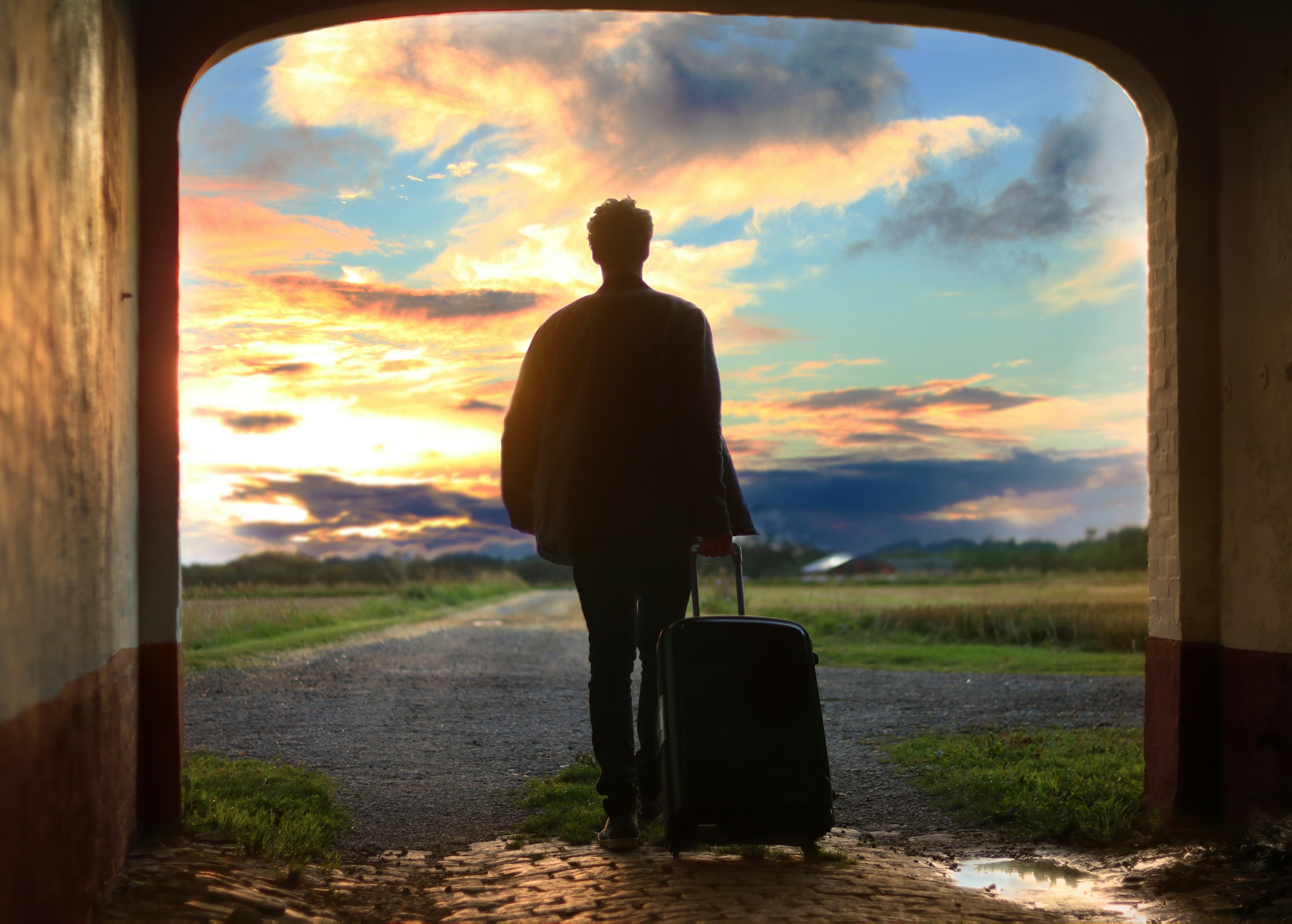 A back view of a young man holding his suitcase | Source: Unsplash