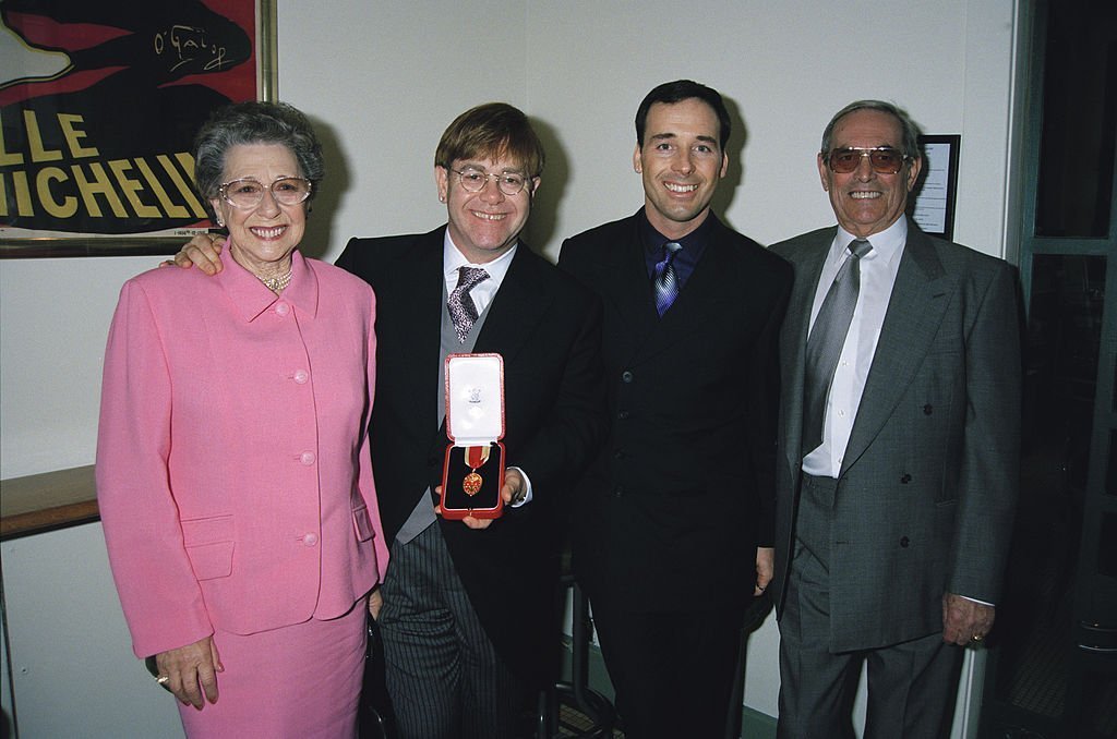 Elton John with his mother Sheila Farebrother, his stepfather and his partner David Furnish, after receiving his knighthood. | Source: Getty Images