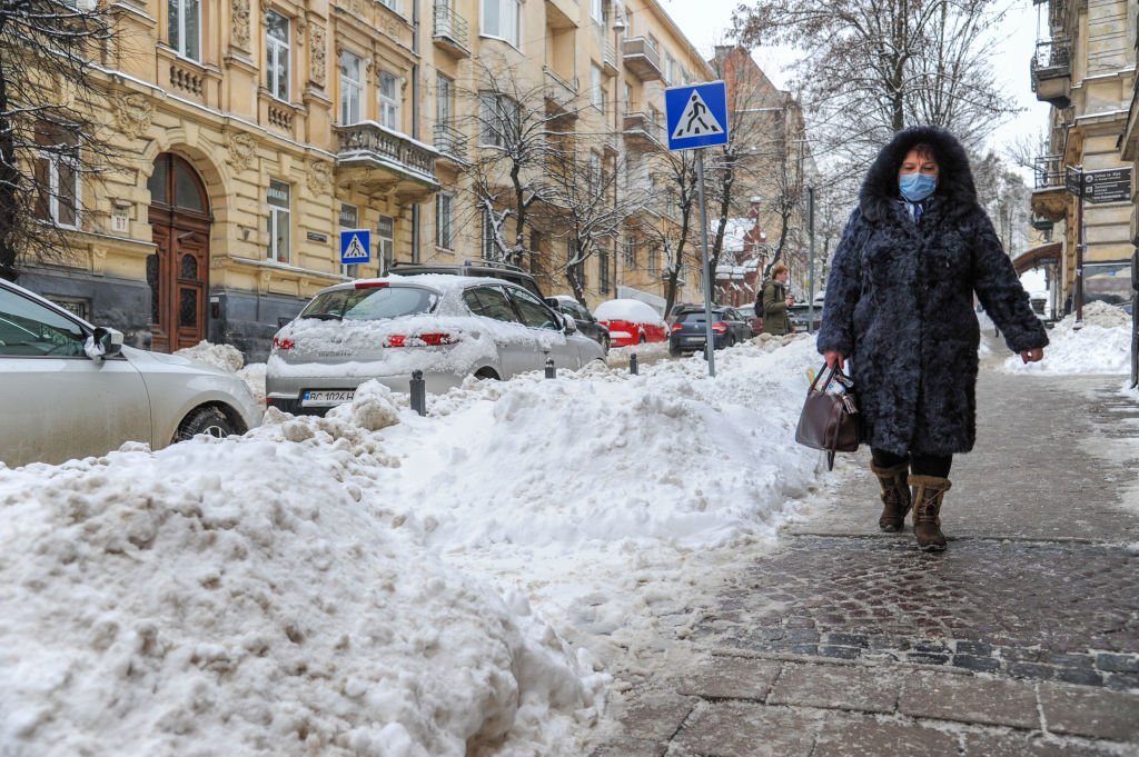 A woman walking on a snow covered street during a snowfall on February 10, 2021 | Photo: Getty Images