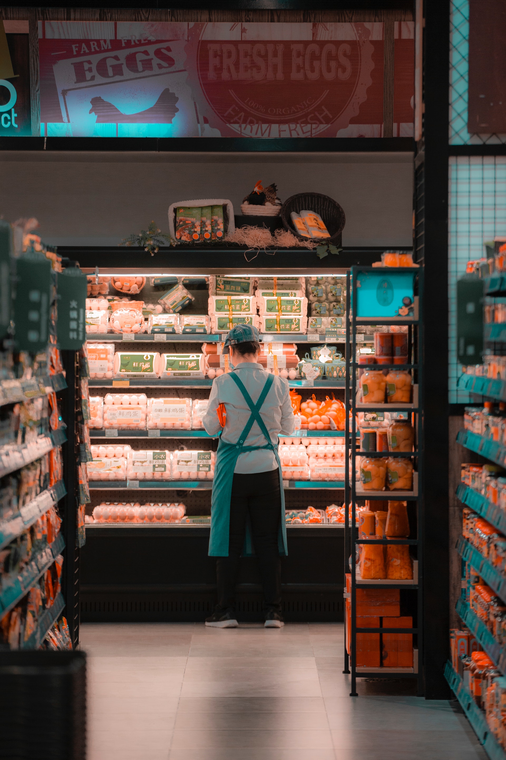 A supermarket employee standing near the refrigerator | Source: Pexels