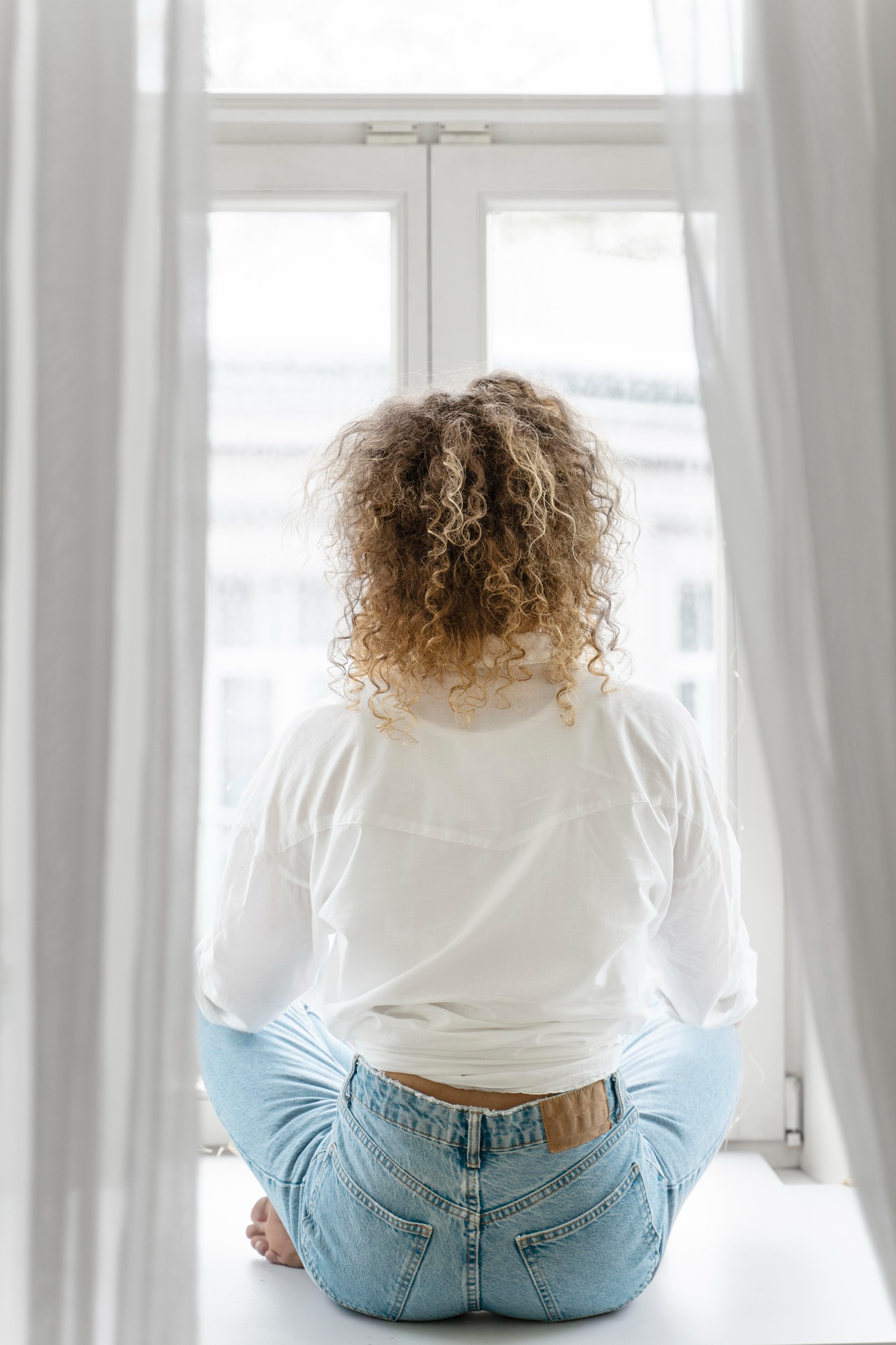 A woman sitting looking through a window