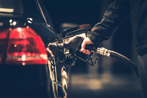Hombre poniendo combustible a su vehículo en la noche. | Foto: Freepik