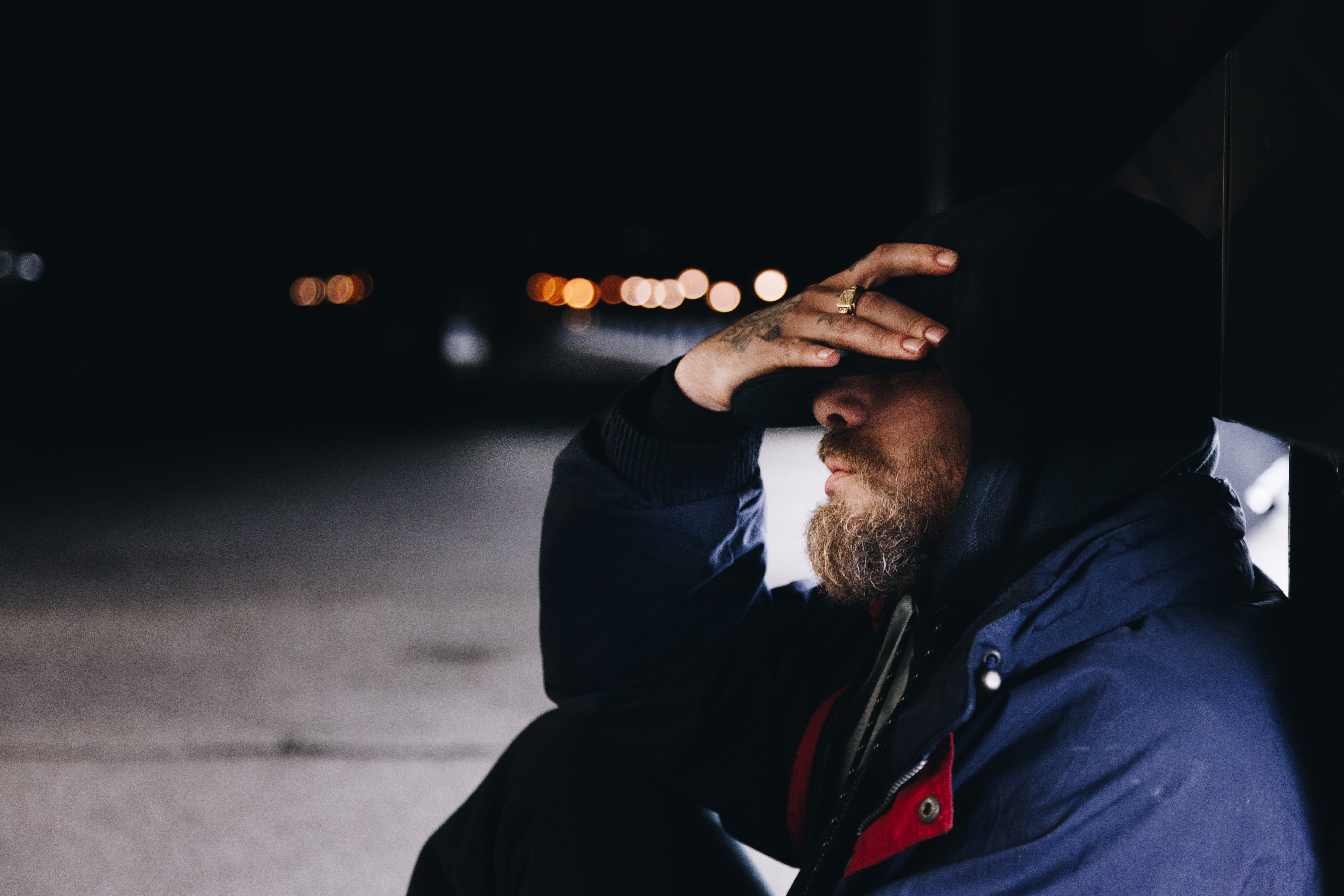 Hombre sentado en la calle bajo la noche. | Foto: Unsplash