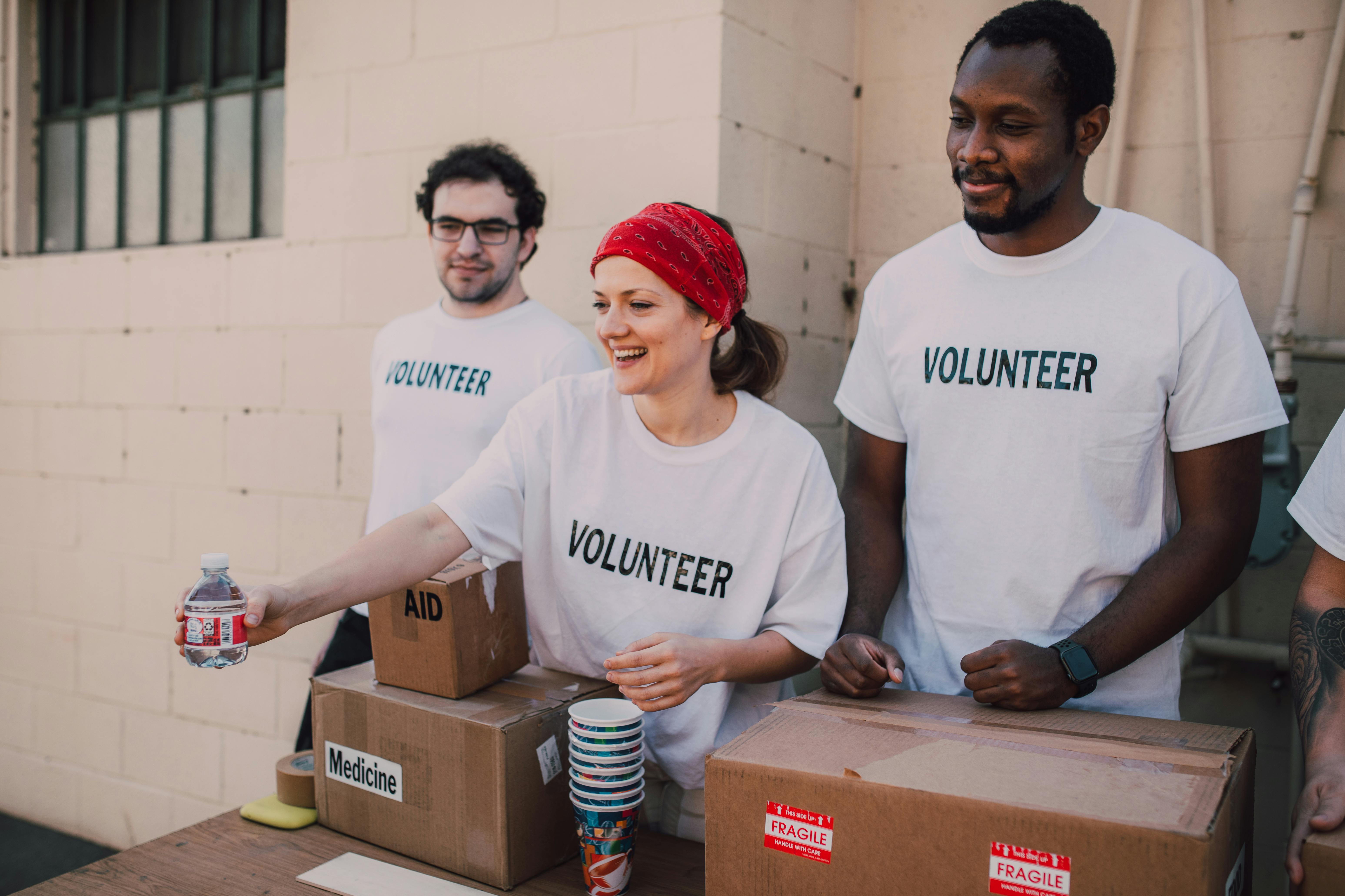 Voluntarios repartiendo artículos de primera necesidad en un centro comunitario | Fuente: Pexels