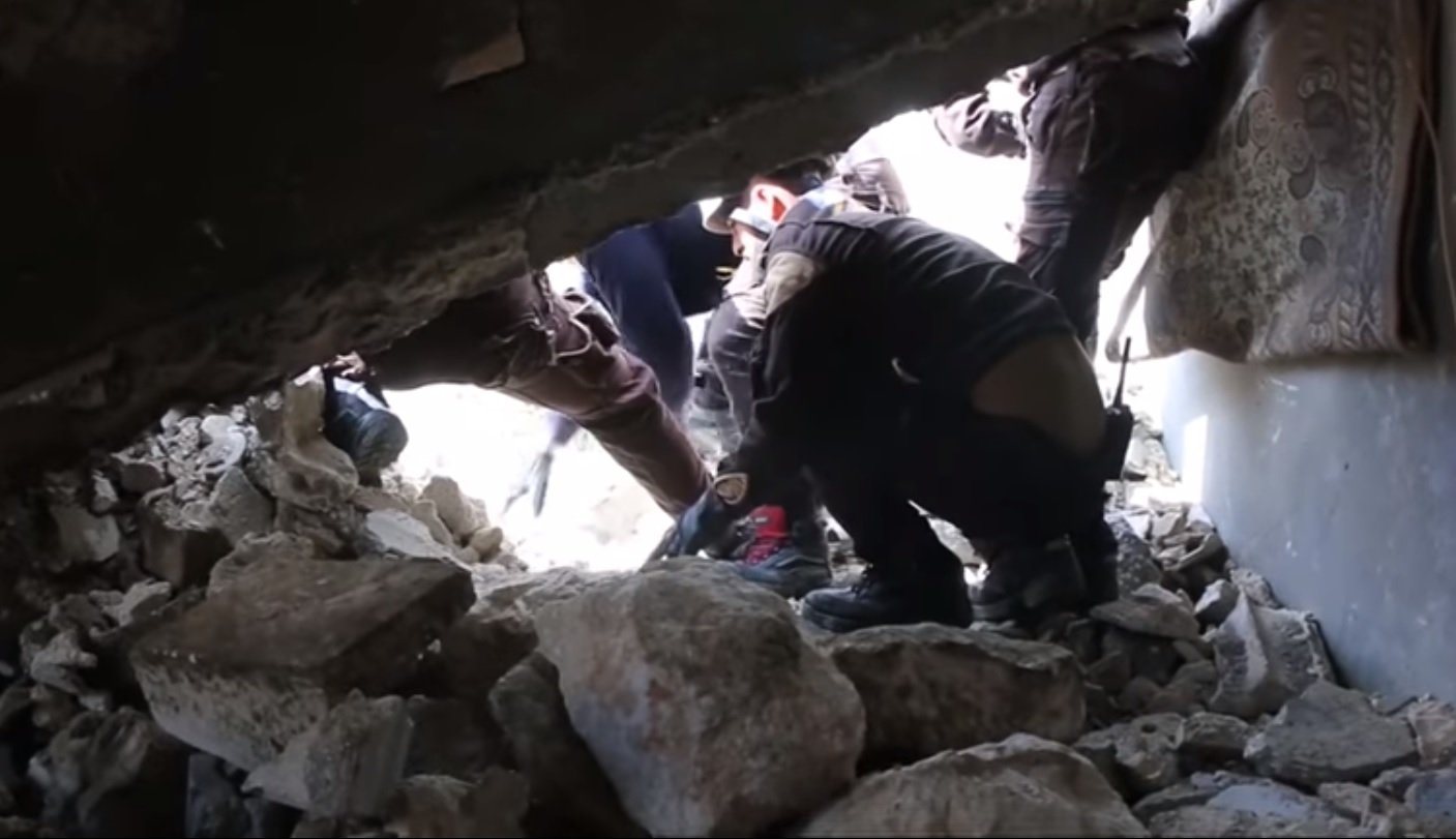 Rescatistas raspando la roca desmenuzada para revelar la cabeza de un pequeño cachorro. Fuente: YouTube / Daily Mail Rescatistas raspando la roca desmenuzada para revelar la cabeza de un pequeño cachorro. Fuente: YouTube / Daily Mail