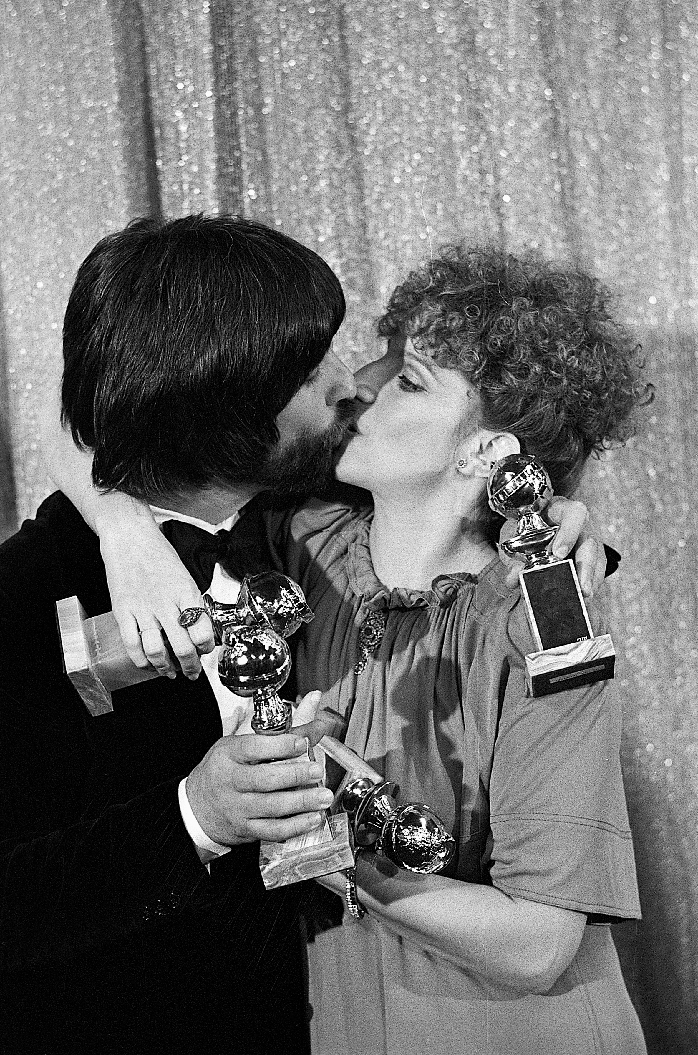 Jon Peters and Barbra Streisand sharing a kiss at the Golden Globes in Hollywood, 1977 | Source: Getty Images