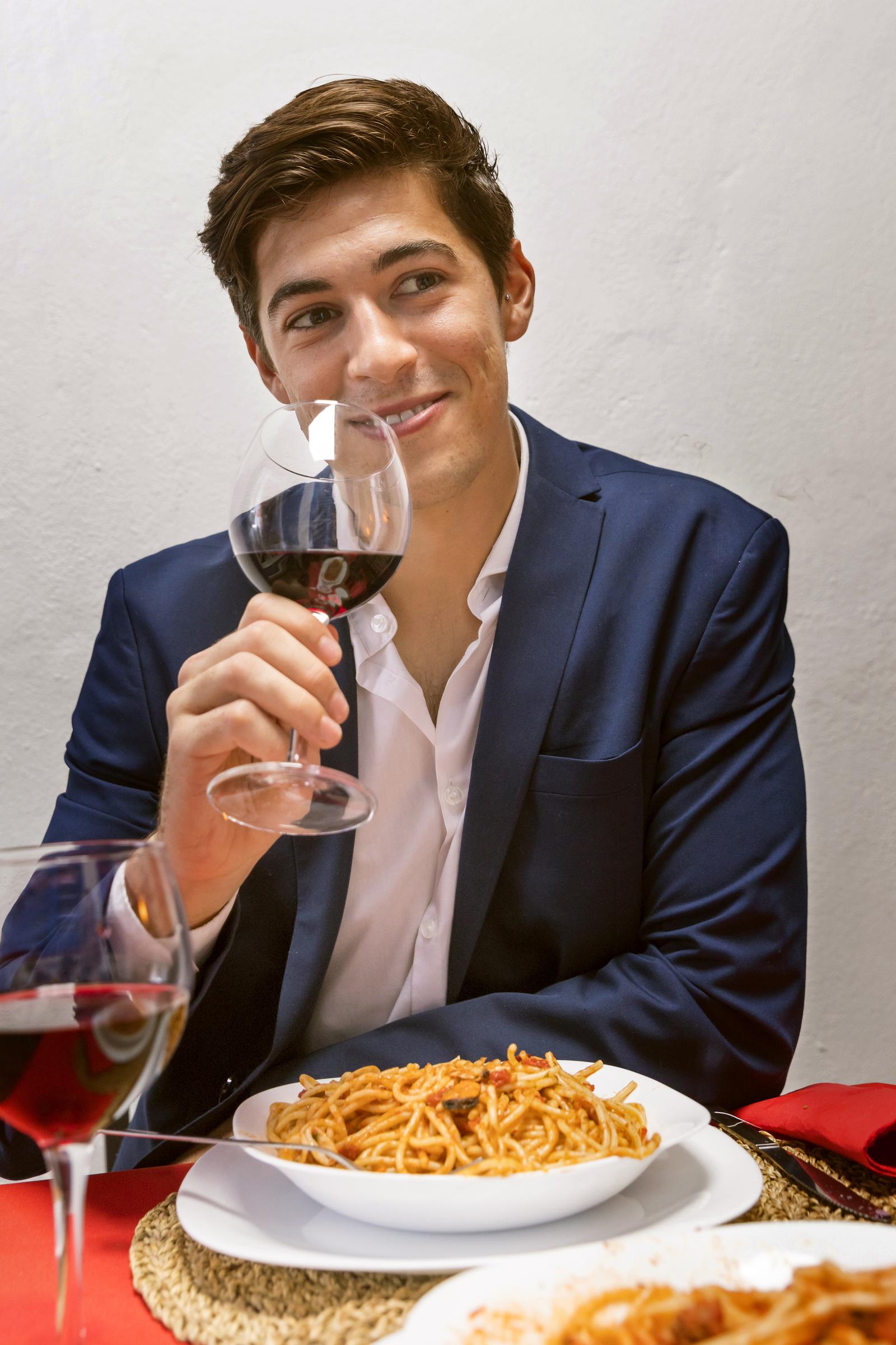 A man smiling at a dinner table | Source: Freepik