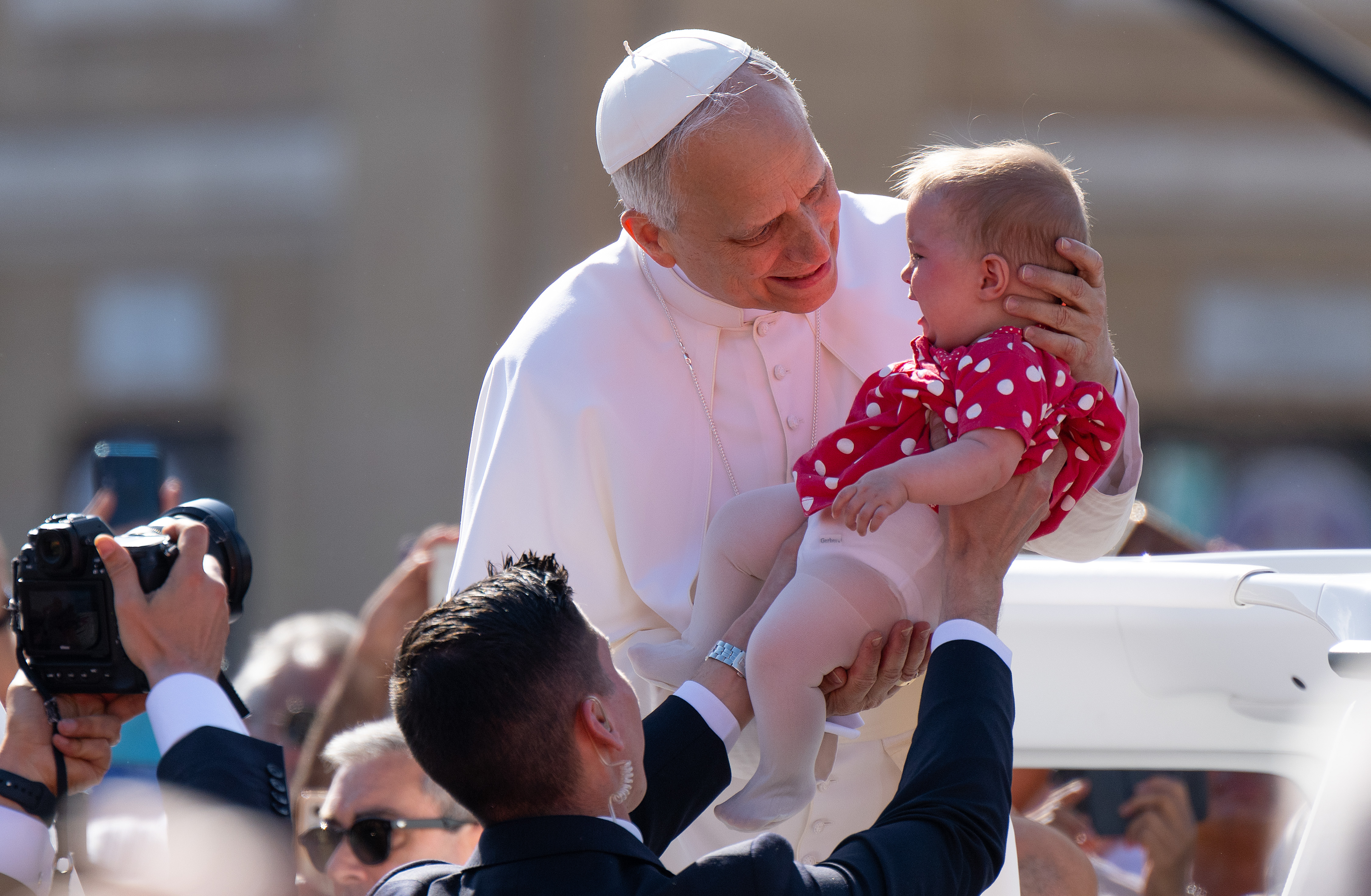 Pope Leo XIV holding a baby ahead of his Inauguration Mass in St. Peter's Square on May 18, 2025, in Vatican City, Vatican. | Source: Getty Images