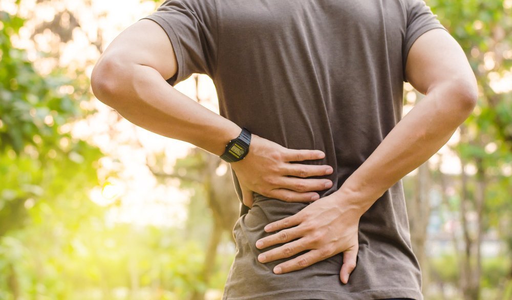 Man holding his lower back in distress | Photo: Shutterstock