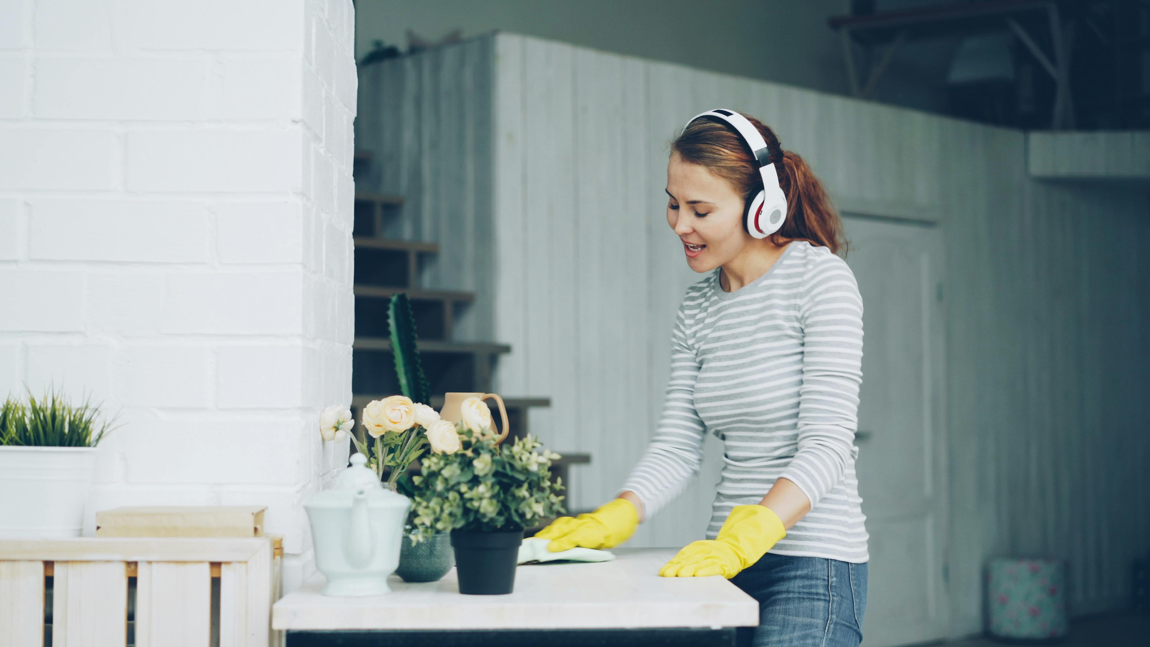 A woman wipes down a countertop, showing how regular cleaning keeps everyday surfaces fresh and hygienic. | Source: Pexels