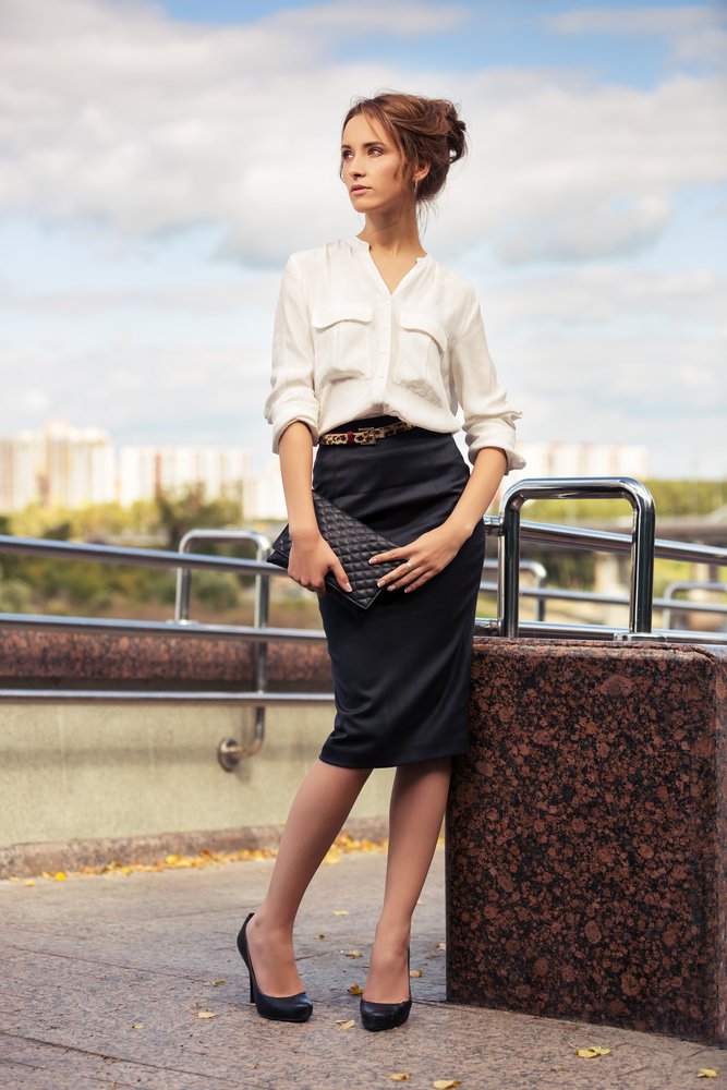 Mujer usando una blusa de color claro combinada conuna falda negra. | Foto: Shutterstock