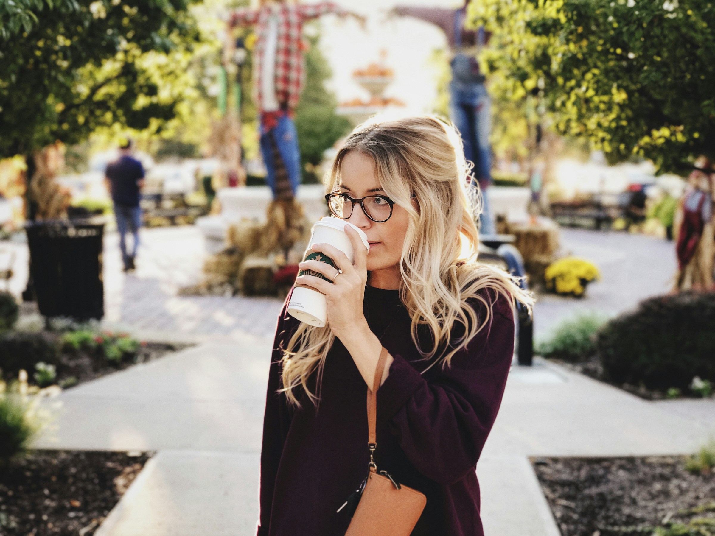 A woman drinking coffee while walking outside | Source: Unsplash