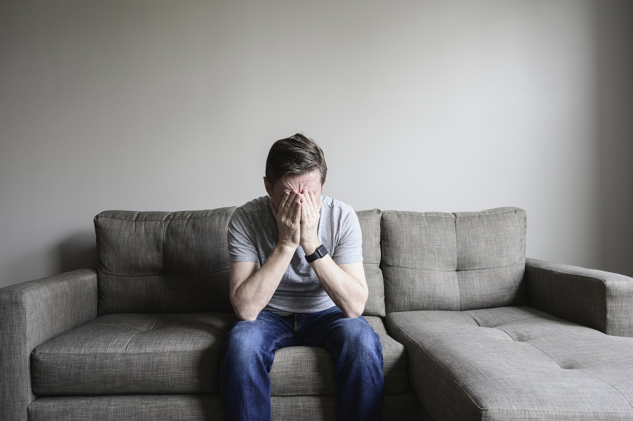 Deprimierter reifer Mann, der auf Couch sitzt. I Quelle: Getty Images