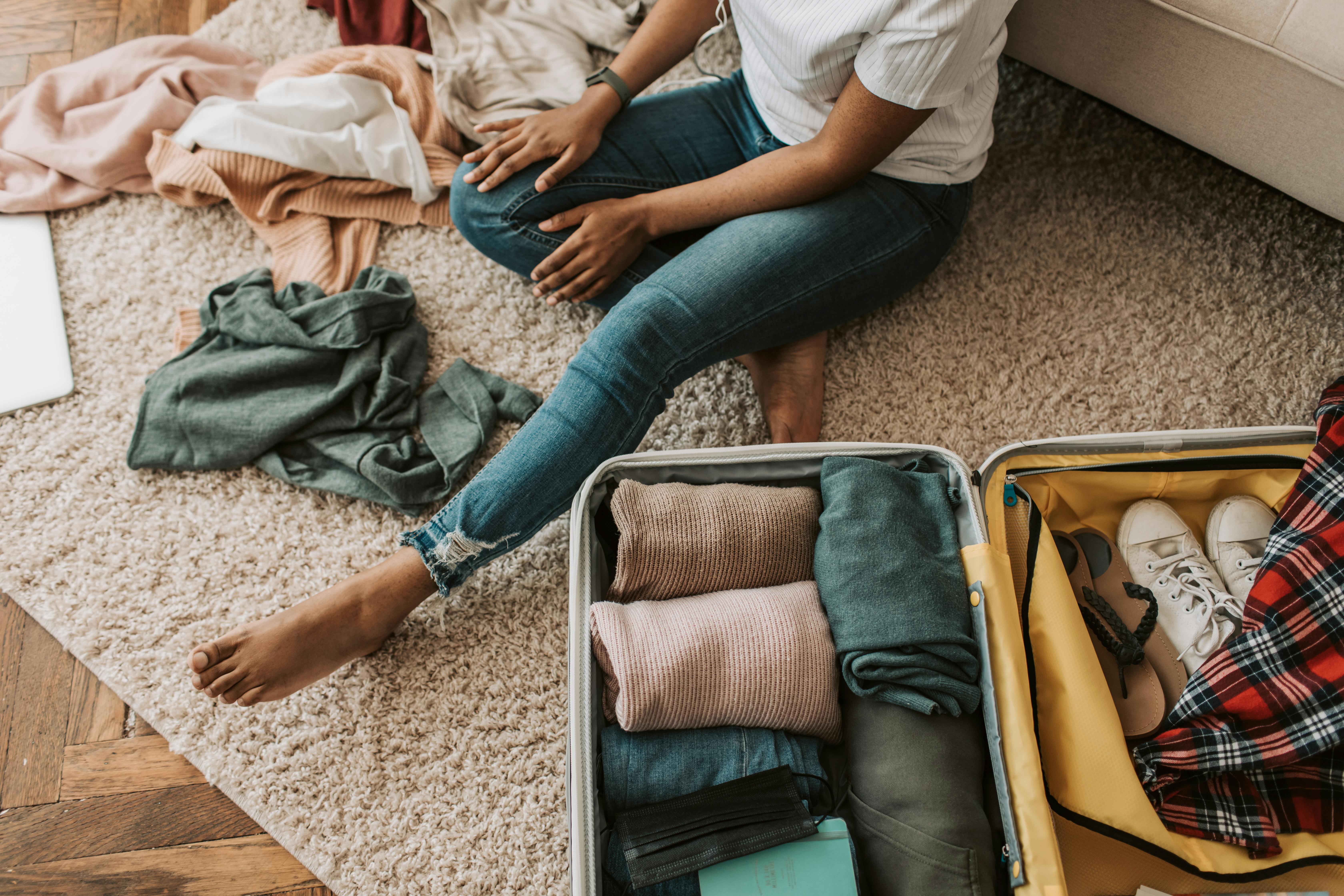 A woman arranging her clothes and suitcase | Source: Pexels
