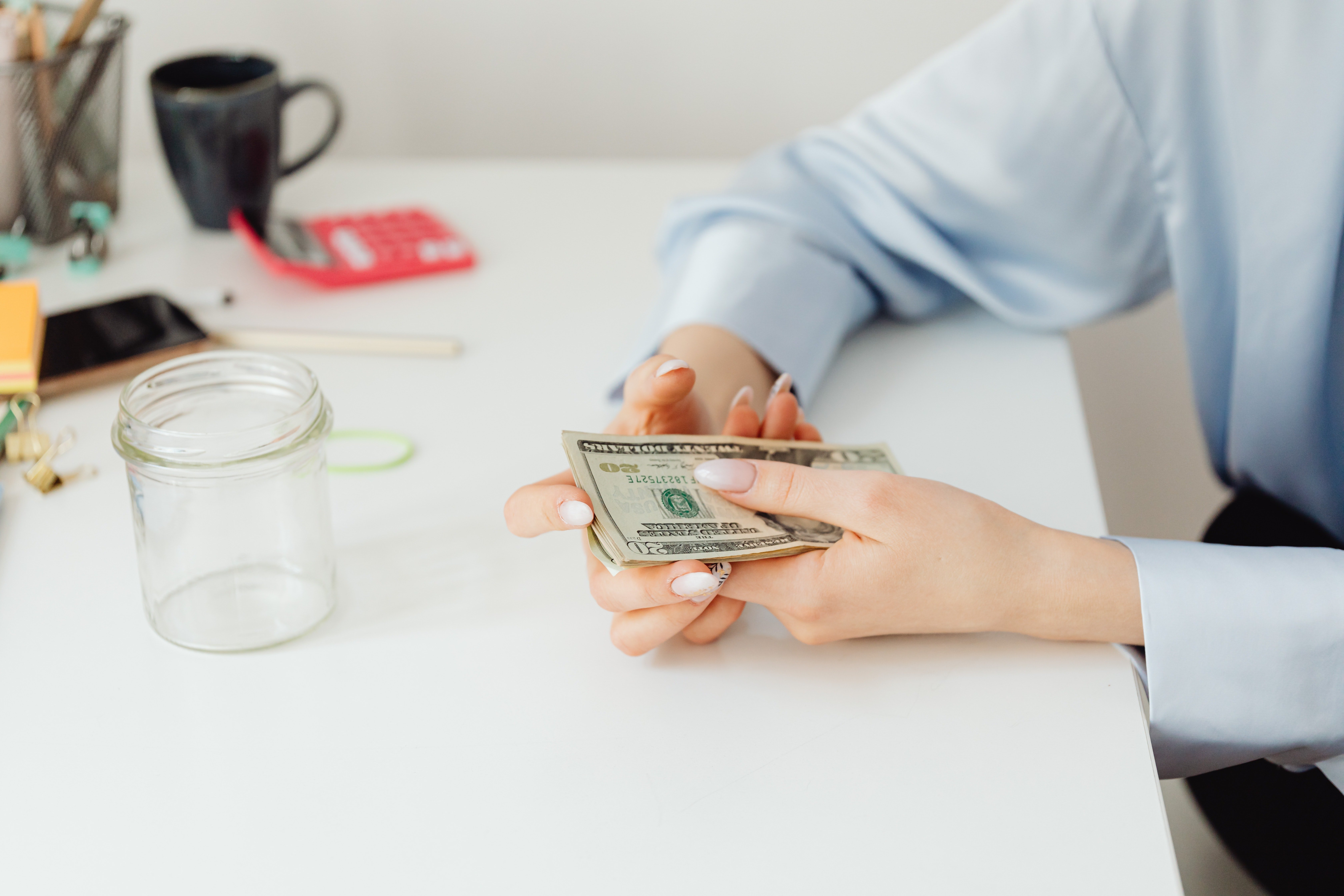 Persona sosteniendo algunos dólares. | Foto: Pexels